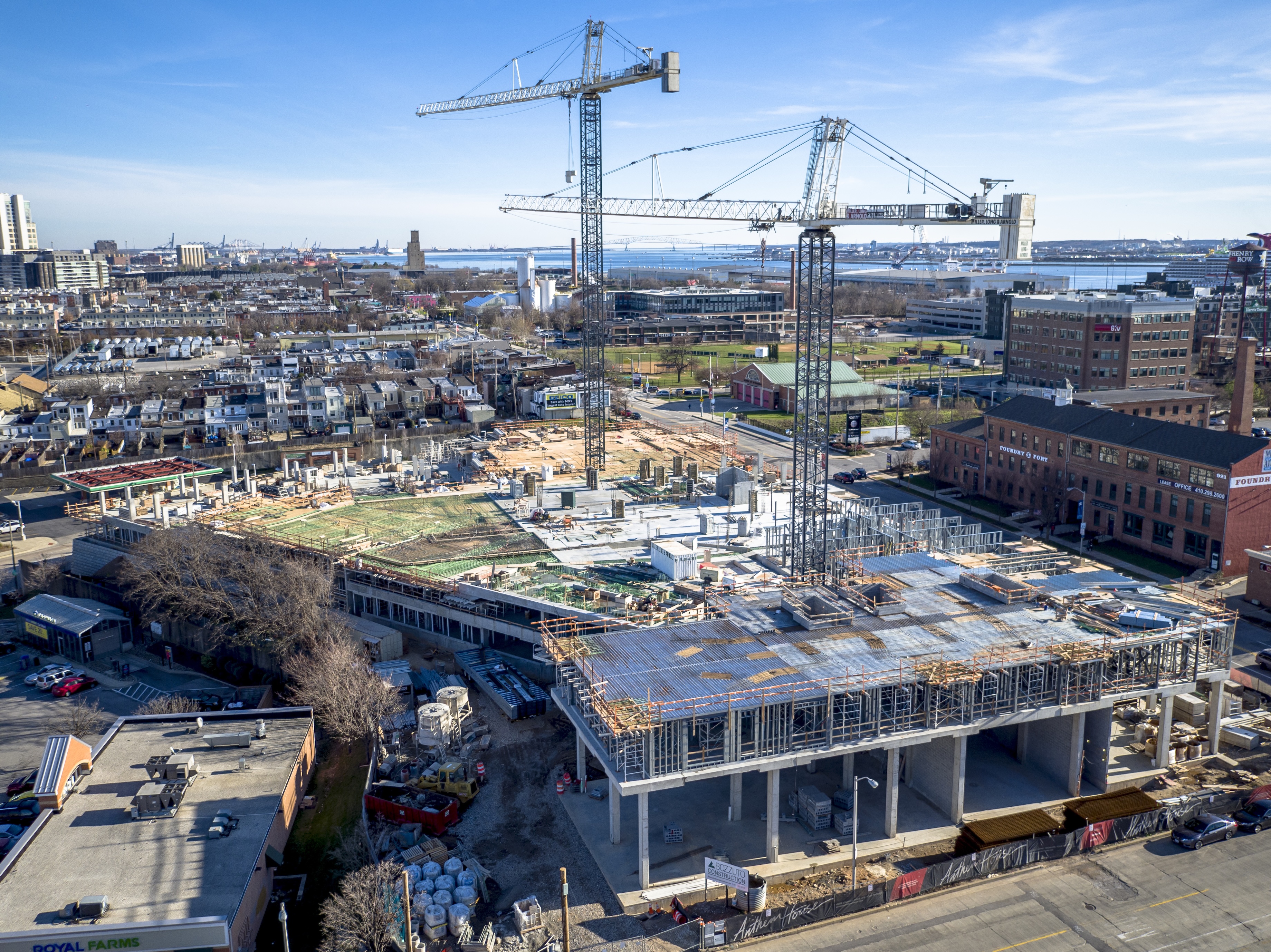 Construction site with cranes over a partially built modern structure.