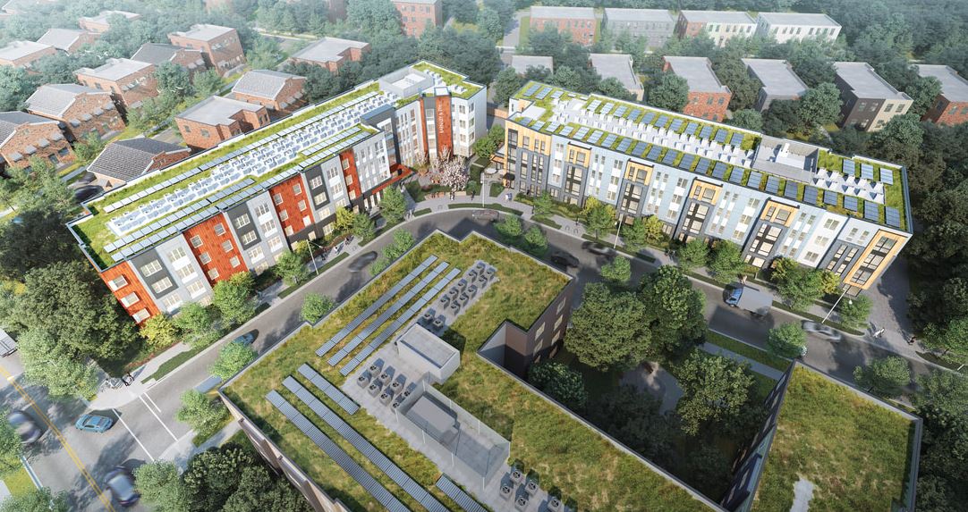 Aerial view of two modern buildings with green roofs and surrounding greenery.