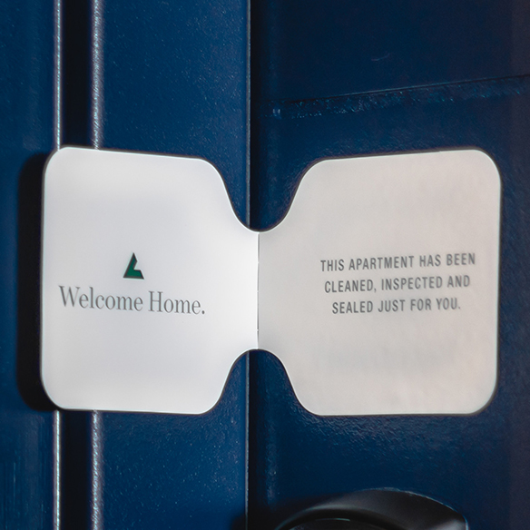 A welcome card on a blue door, indicating a cleaned apartment.