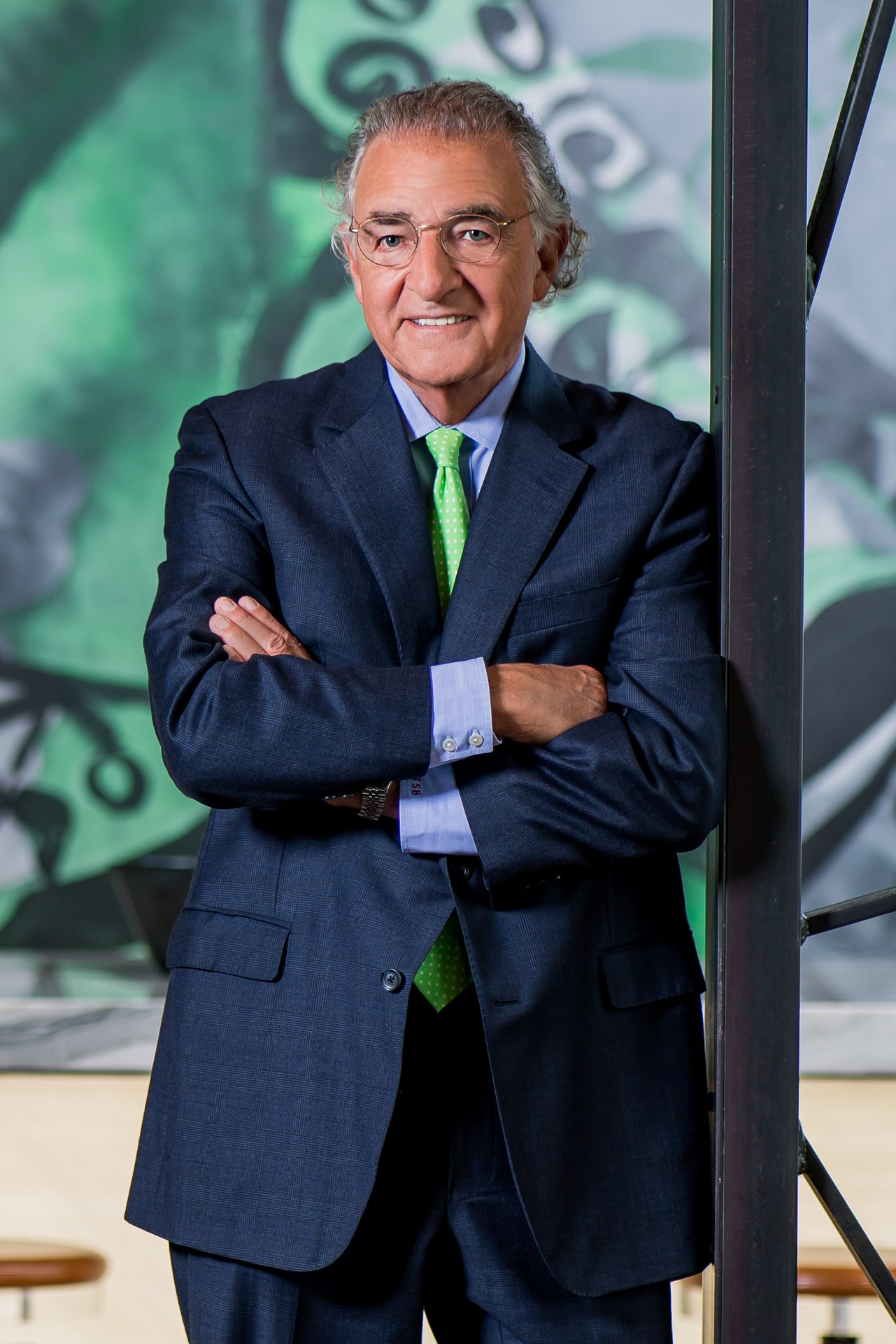 Thomas S. Bozzuto stands confidently with arms crossed in a business setting.