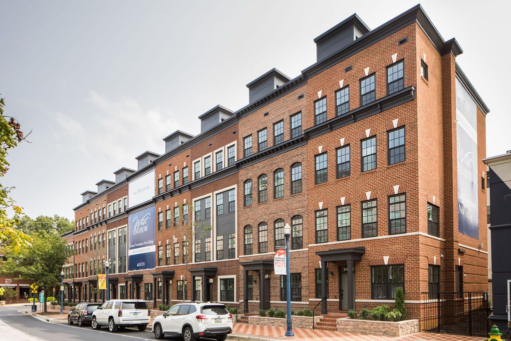 Modern brick townhouse with multiple stories and large windows.