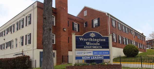 Brick apartment building with a sign for Worthington Woods Apartments.