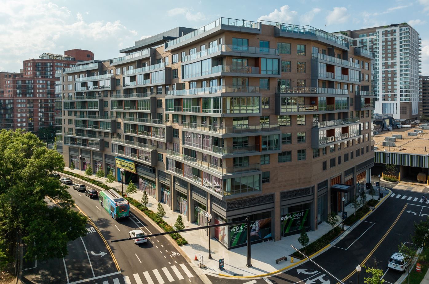 Modern multi-story building with glass balconies and urban surroundings.