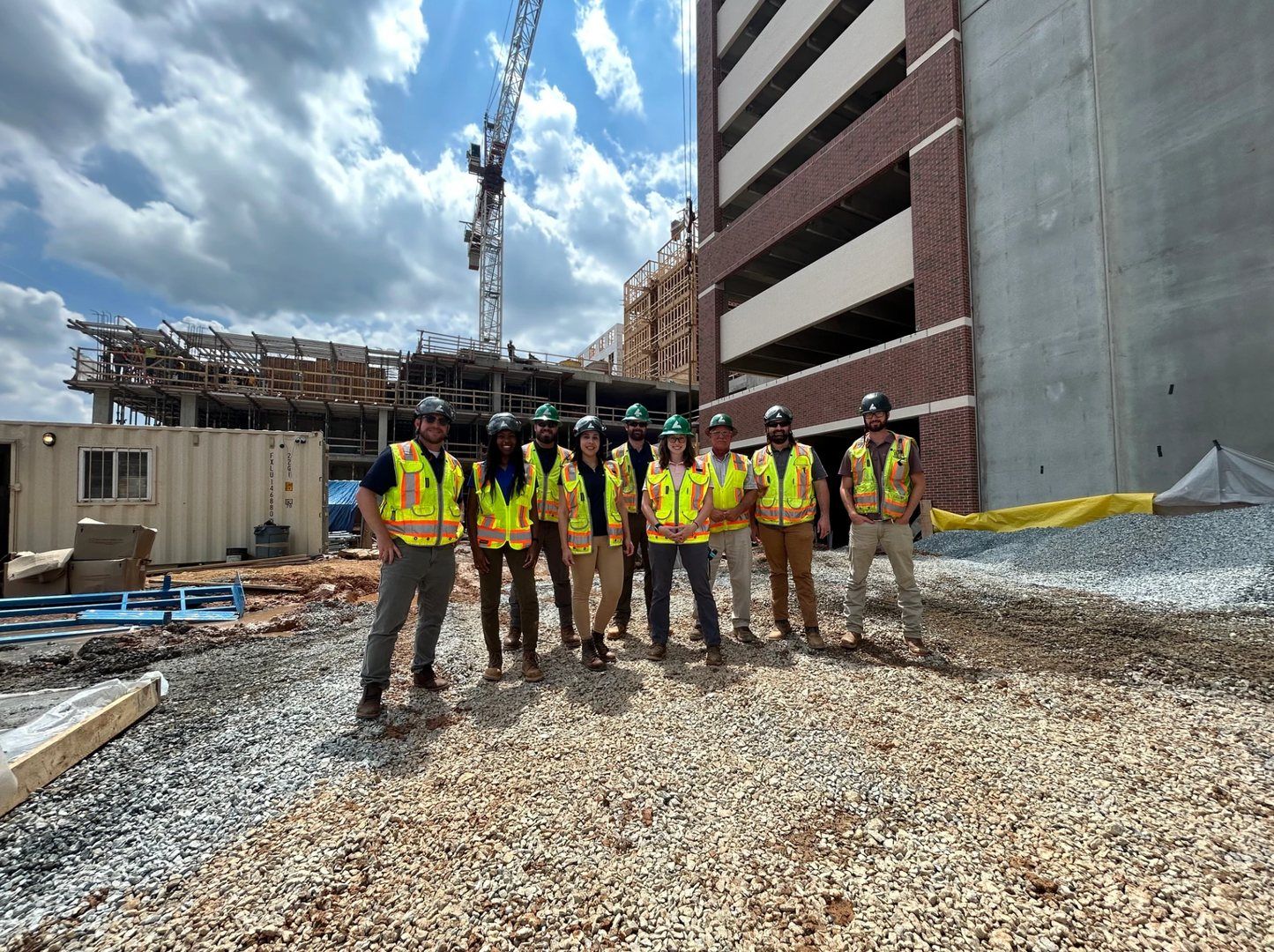Group of construction workers in safety vests at a building site.