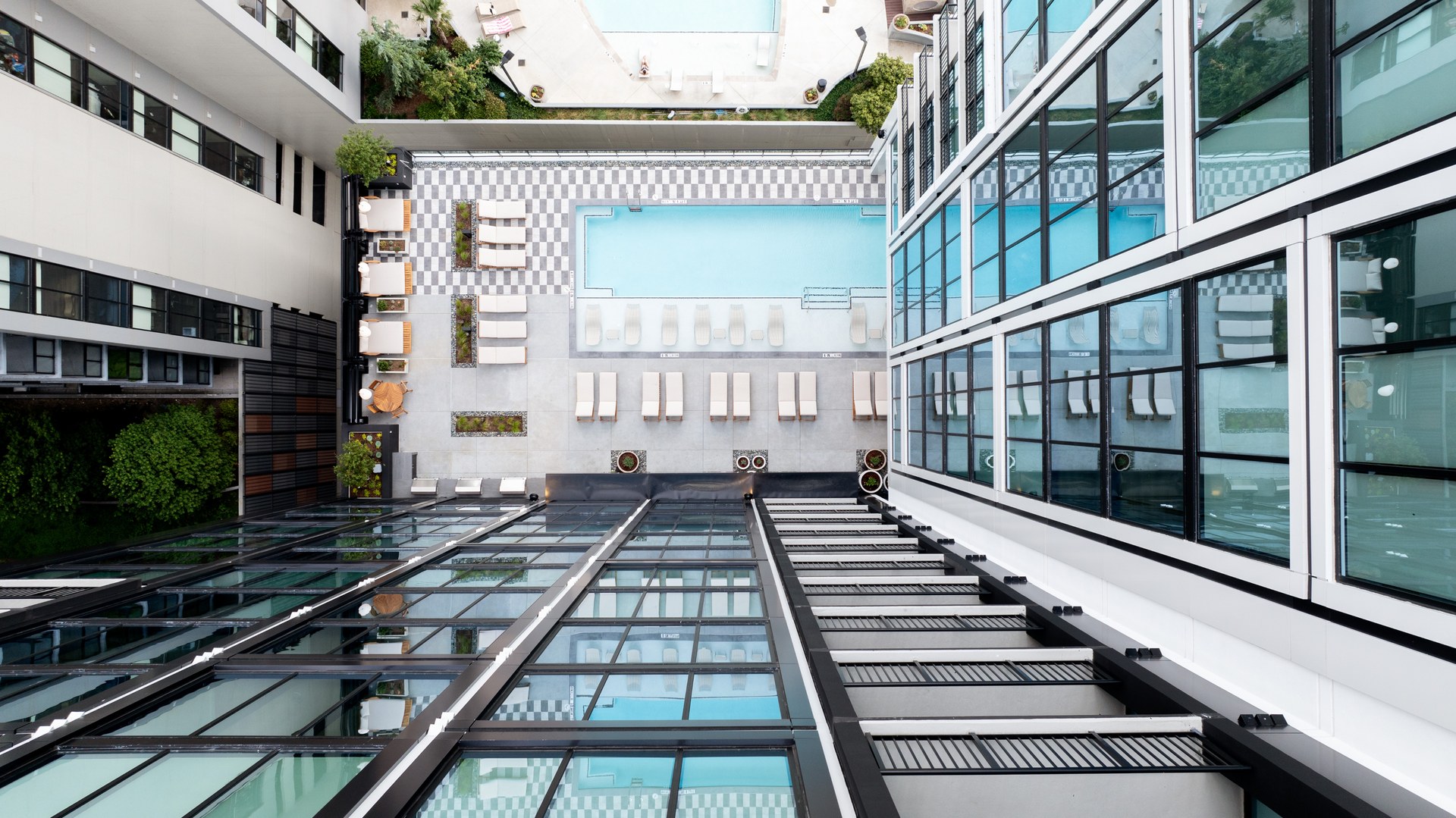 Aerial view of modern buildings with a swimming pool and reflective glass.