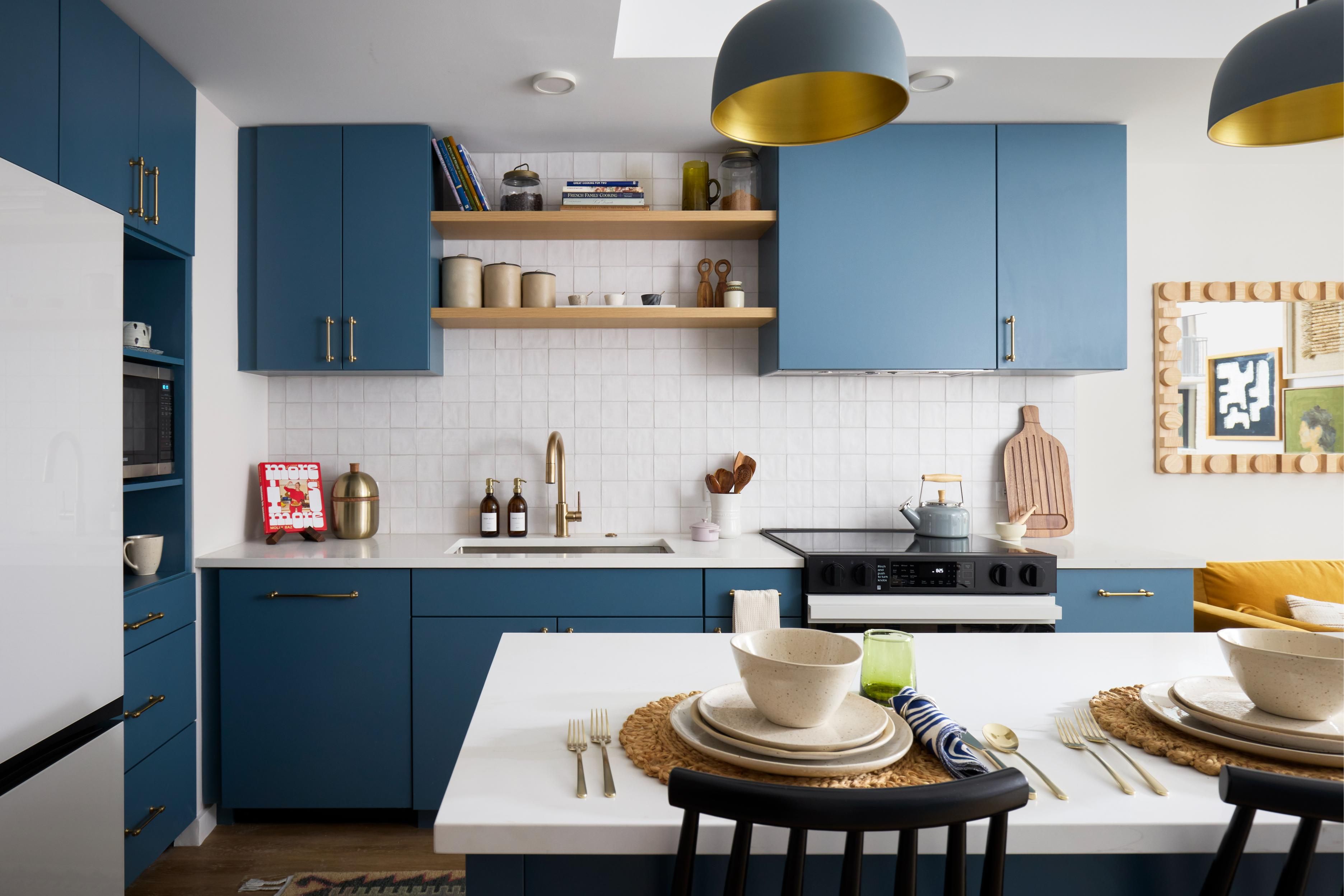 Modern kitchen with blue cabinets, open shelving, and minimalist decor.