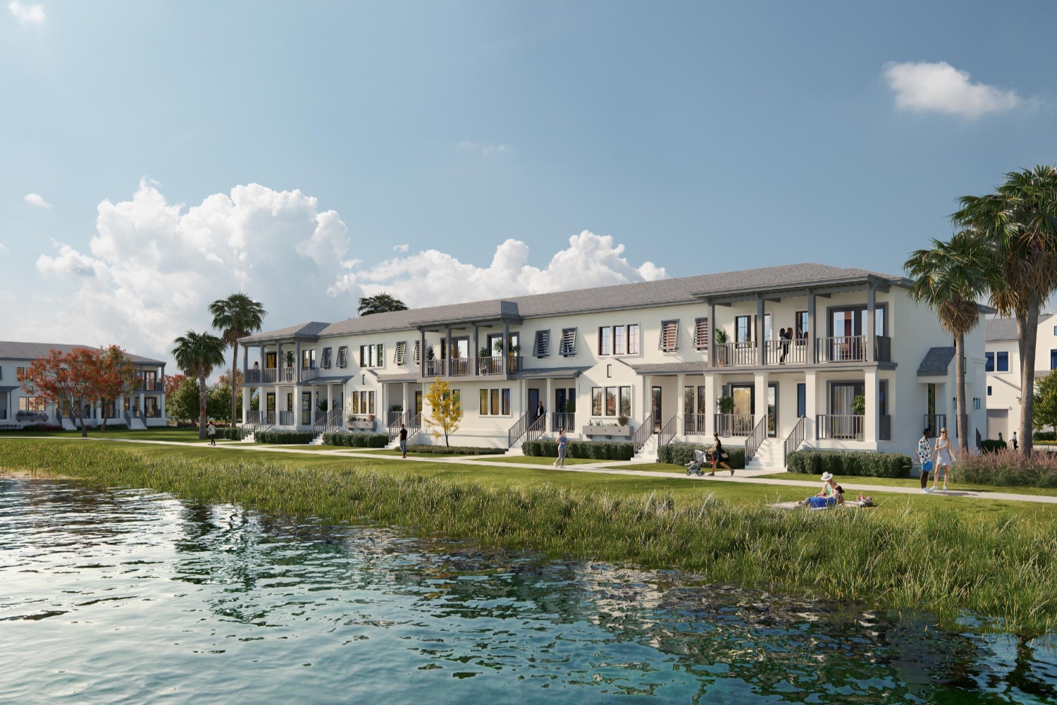 Row of modern buildings by a serene water body under a clear blue sky.