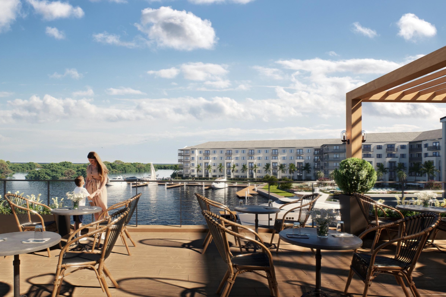 Scenic waterfront view with a couple and outdoor seating at a resort.