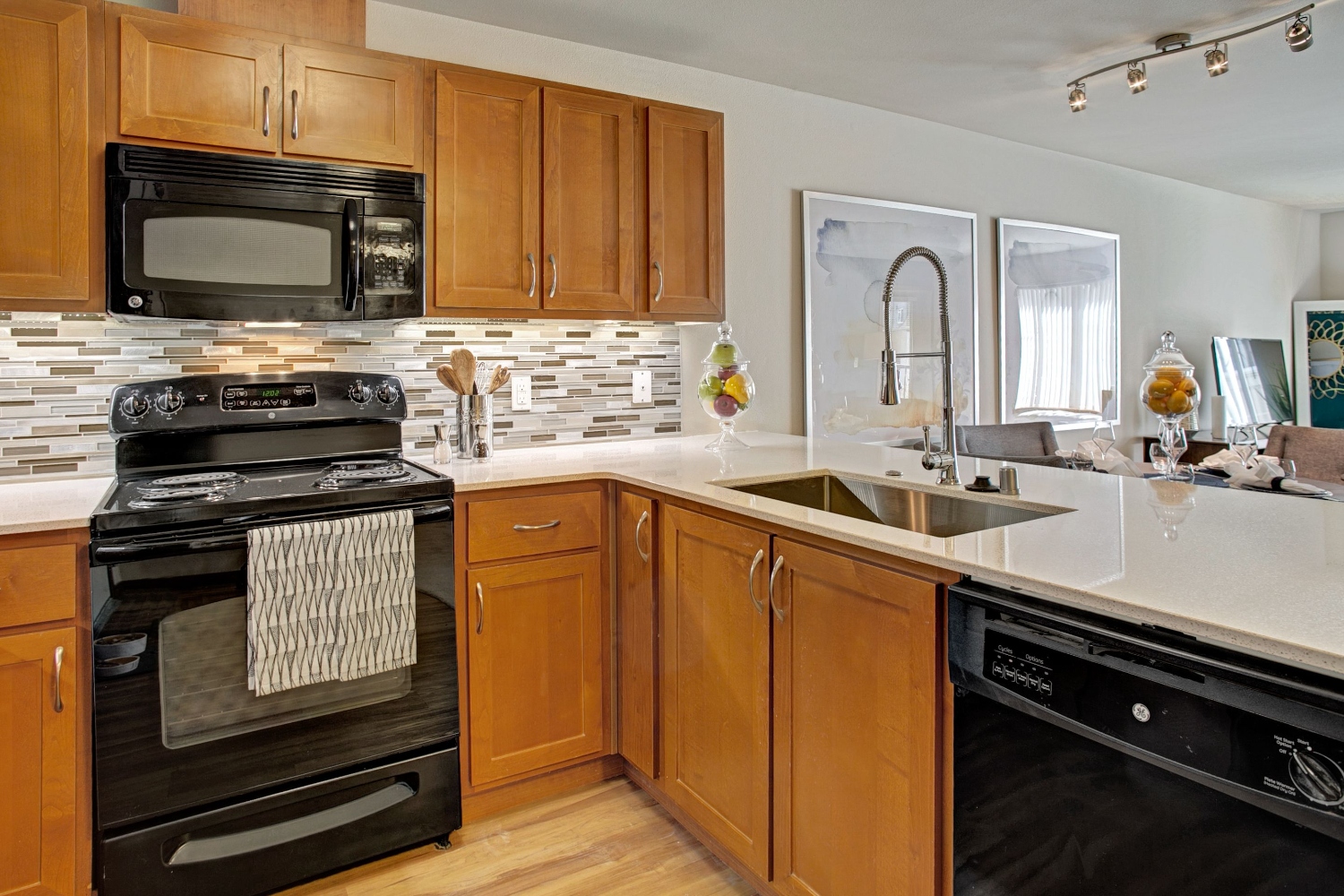 Modern kitchen with dark appliances and wooden cabinets.