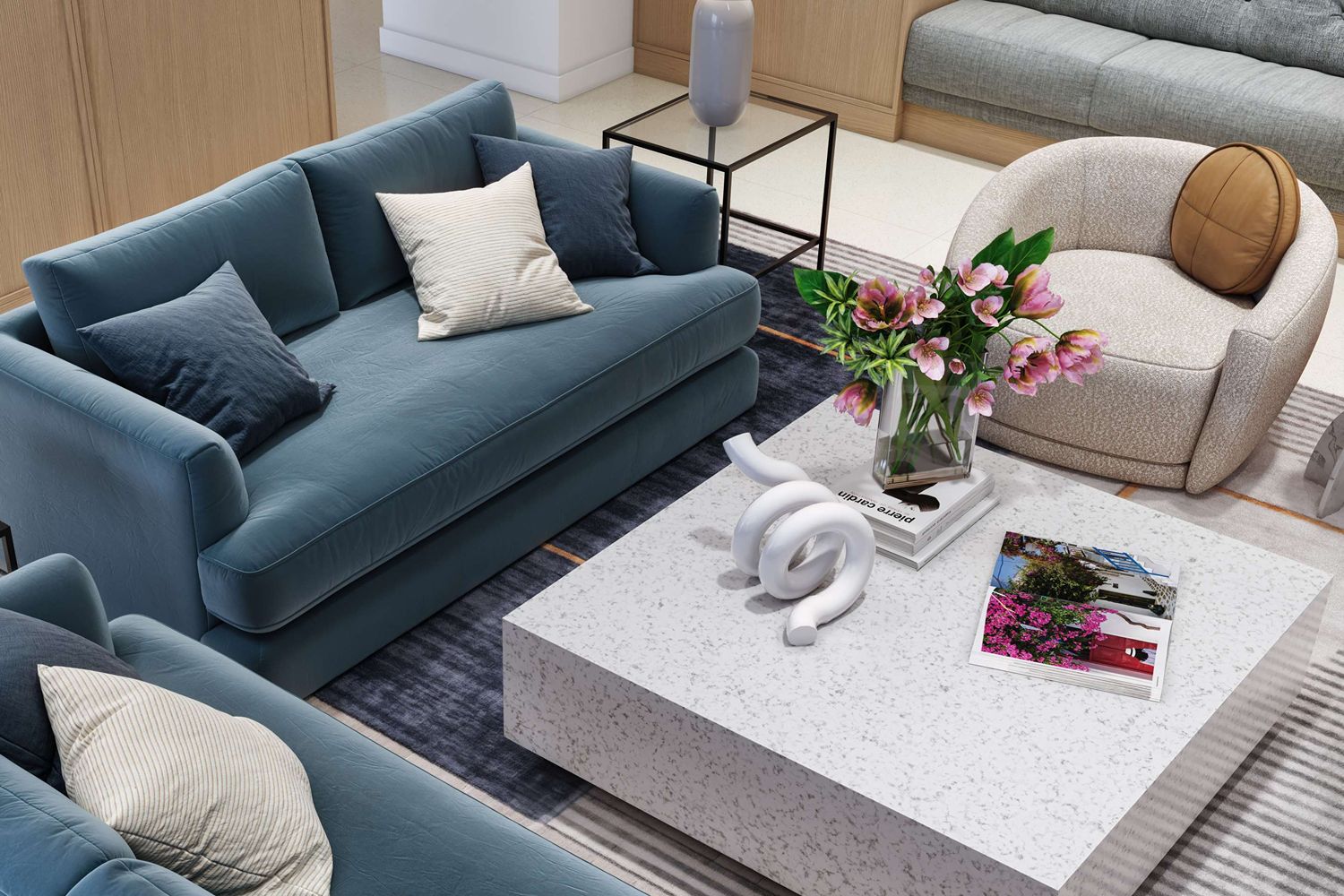 A stylish living room with blue sofas, a coffee table, and floral decor.