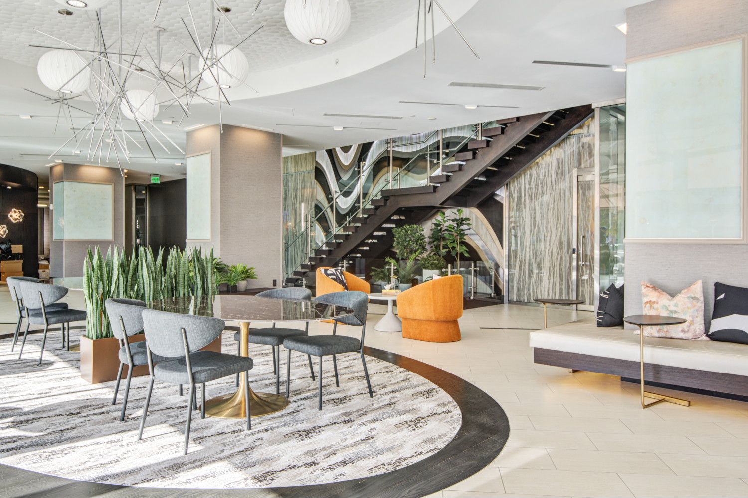 Lobby with lounging areas, grand staircase and mixed media art wall