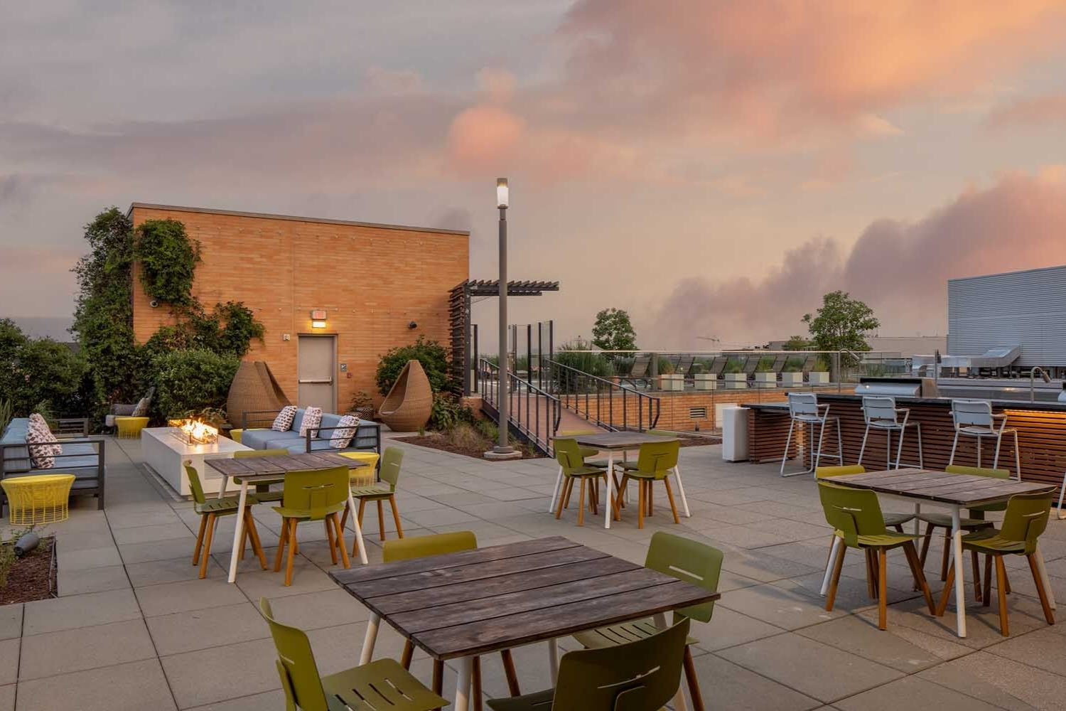 An expansive rooftop sun deck featuring sitting areas and tables for dining