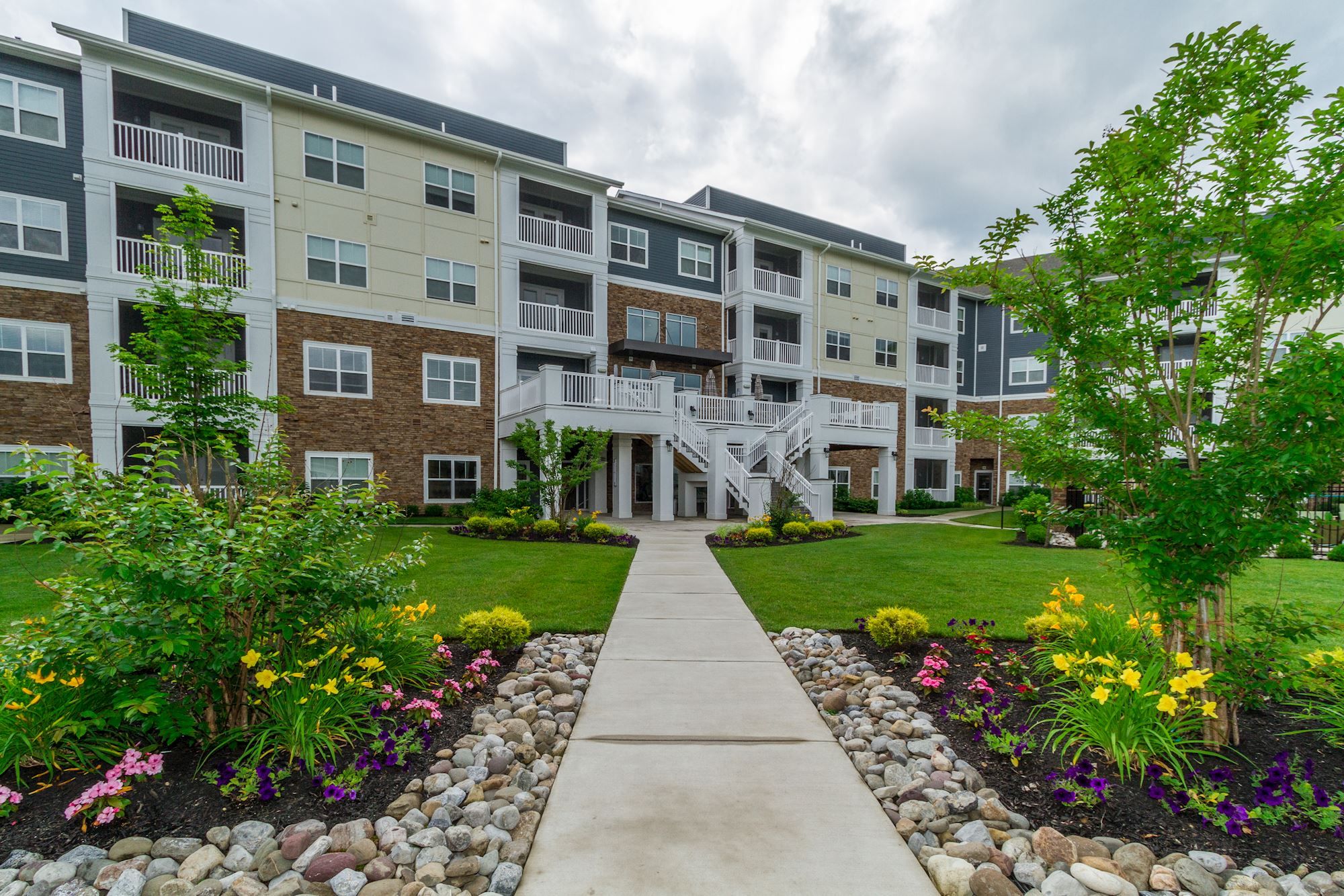 Modern apartment building with landscaped gardens and a clear pathway.