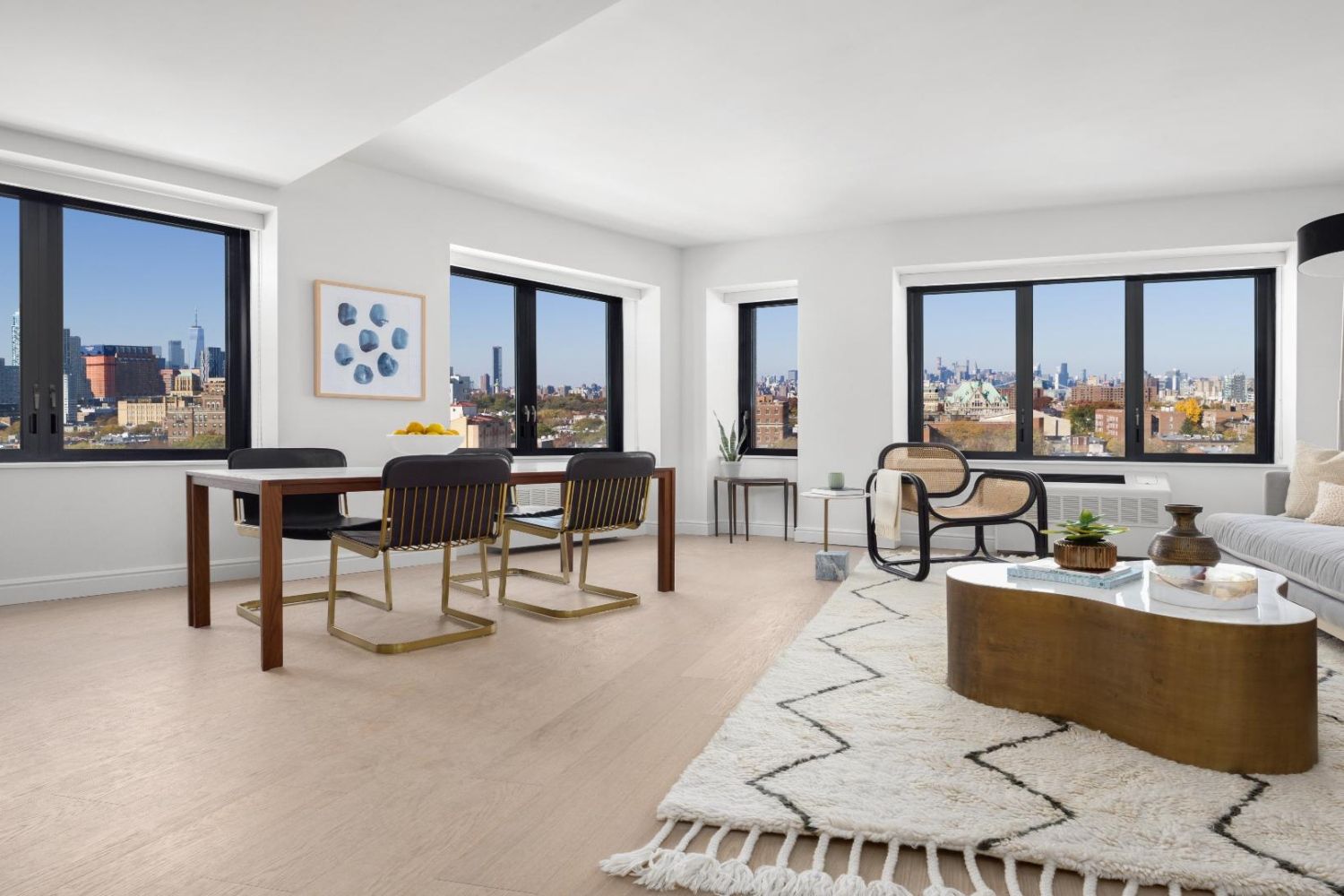 Bright, modern interior featuring a living area and dining space with large windows.