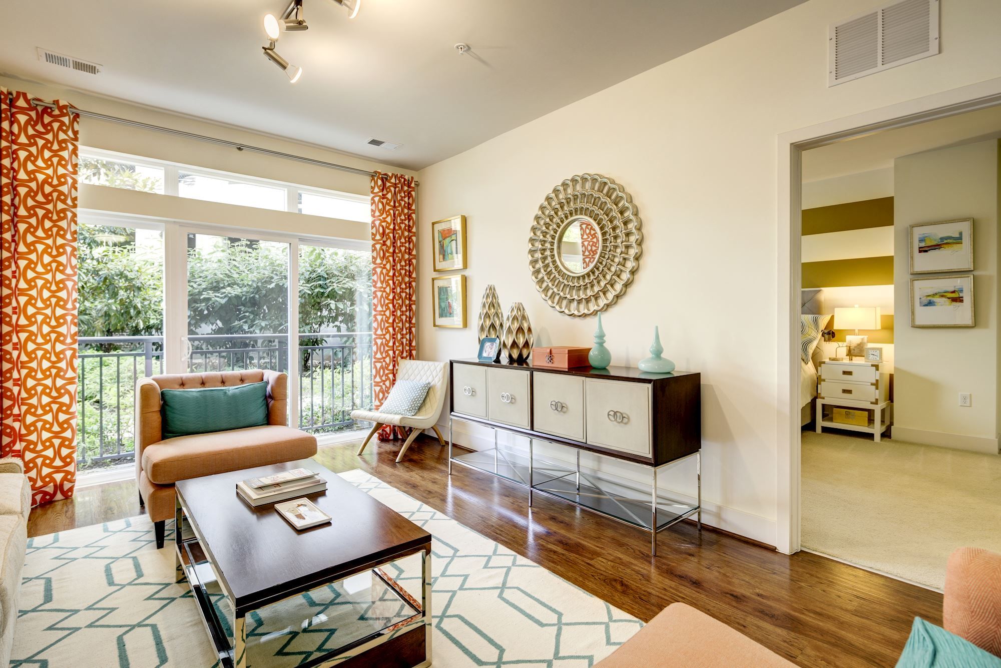 Bright, modern living room with large windows, decorative curtains, and stylish furniture.