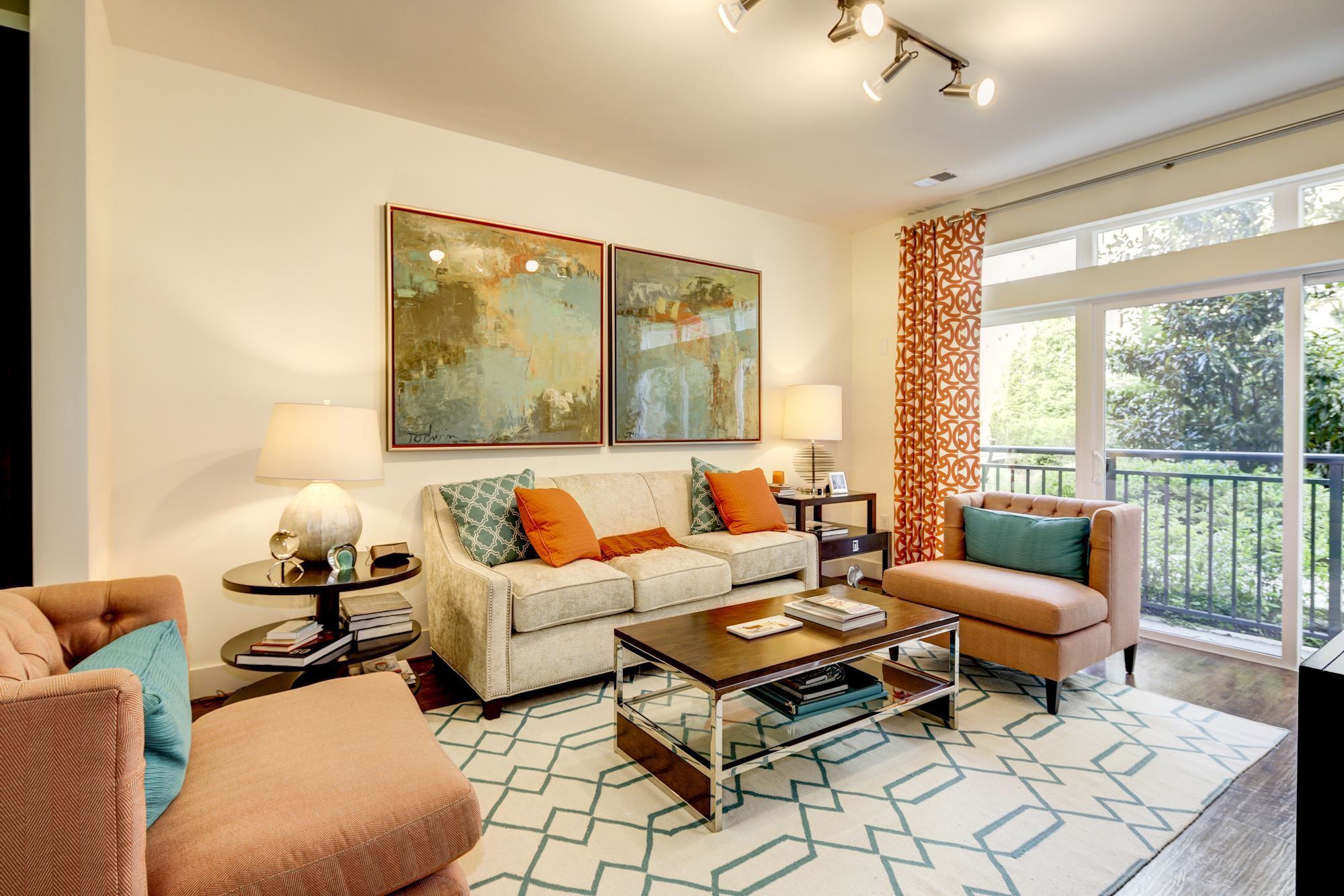 Cozy living room with beige sofas, colorful pillows, artwork, and a coffee table.