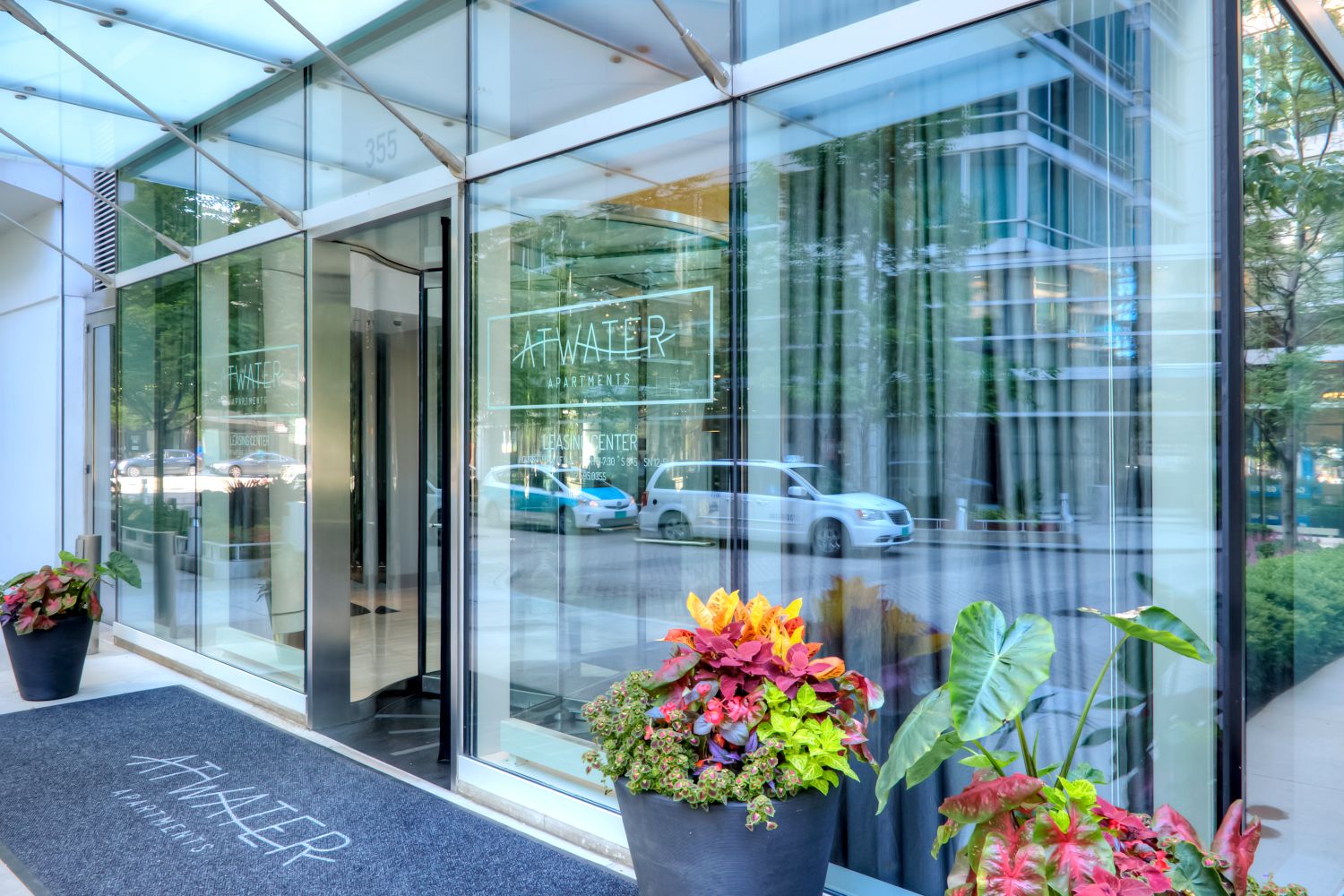 Close up of Atwater's glass façade and front entrance with tall planters positioned by the door.