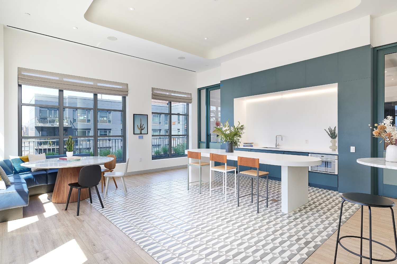 Modern indoor seating area with tables, chairs, and large windows for natural light.
