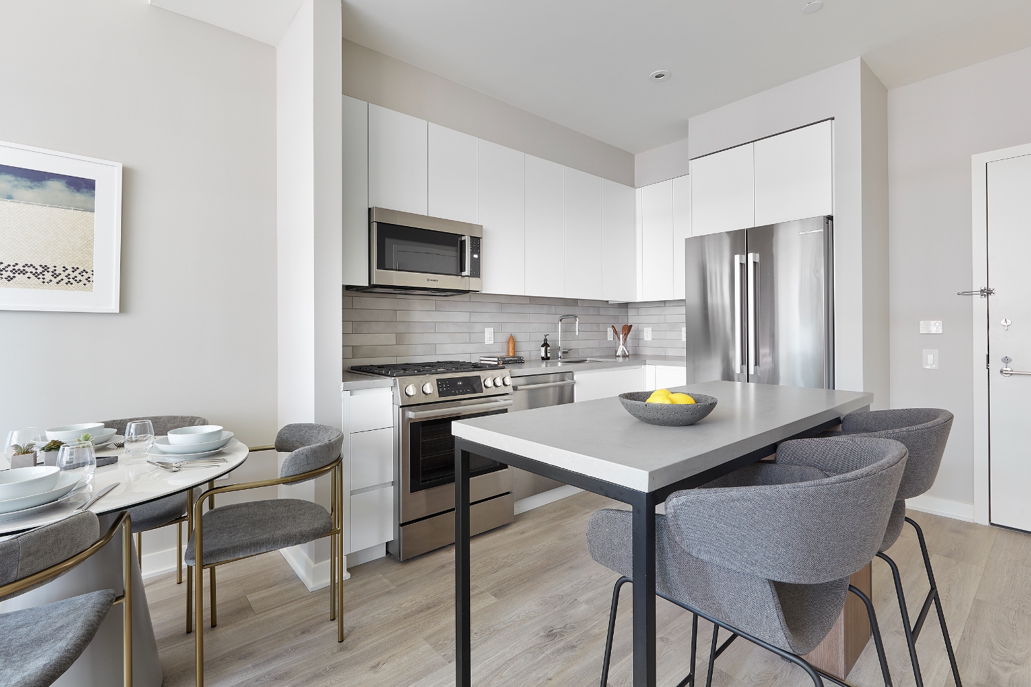Modern kitchen with stainless steel appliances and a dining area with a round table.