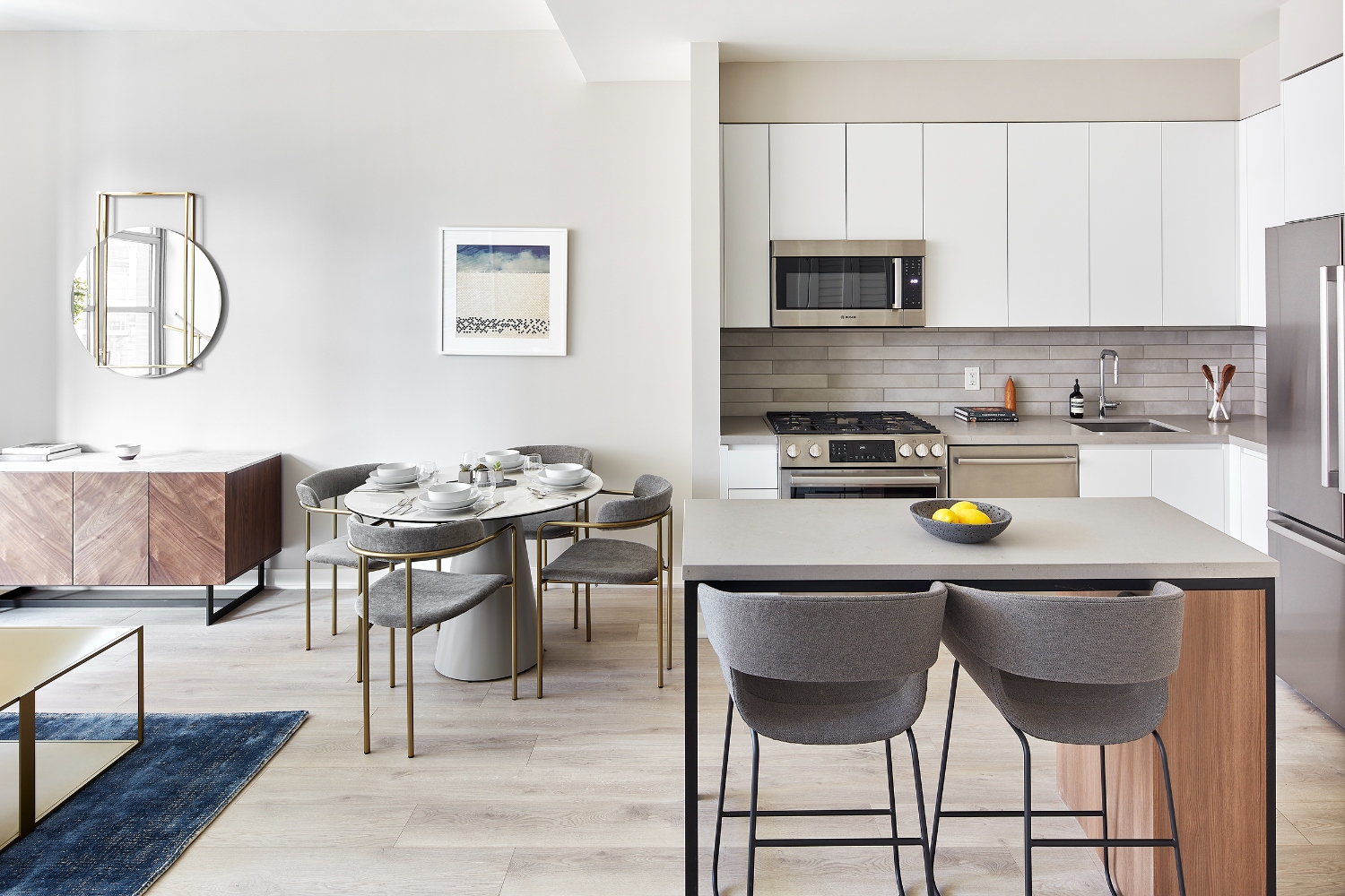 Modern kitchen and dining area with minimalist furniture and decor in neutral tones.