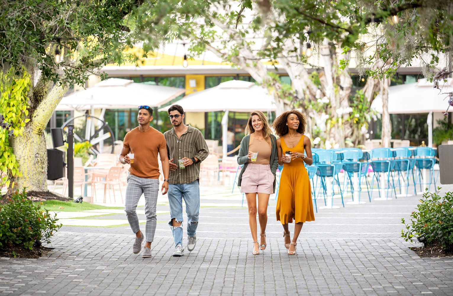 Four friends walking together in a vibrant outdoor setting.