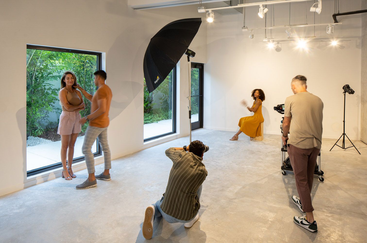 A photoshoot in a bright studio with models and photographers.