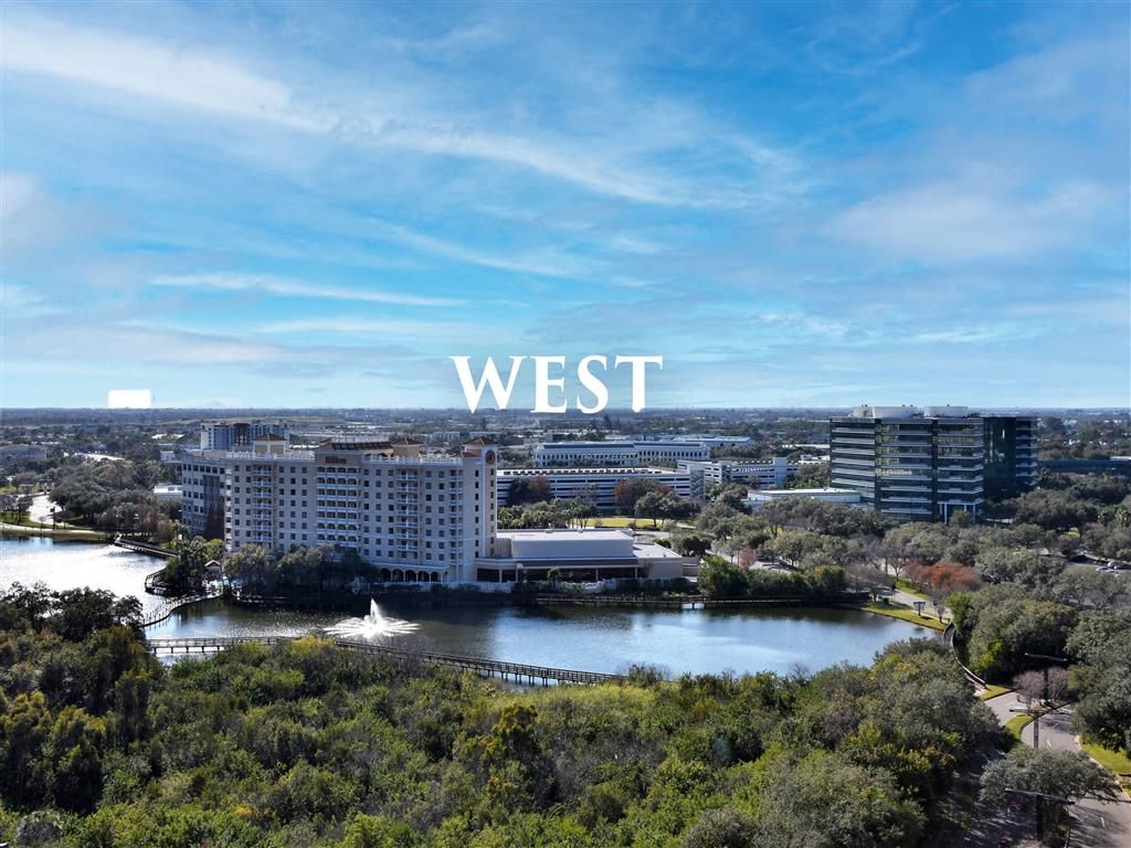 Aerial view of a landscape with buildings, water, and the word "WEST" prominently displayed.