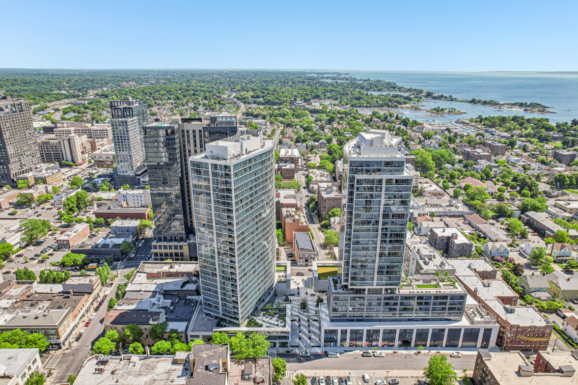 Aerial view of a cityscape with high-rise buildings and a coastal area.