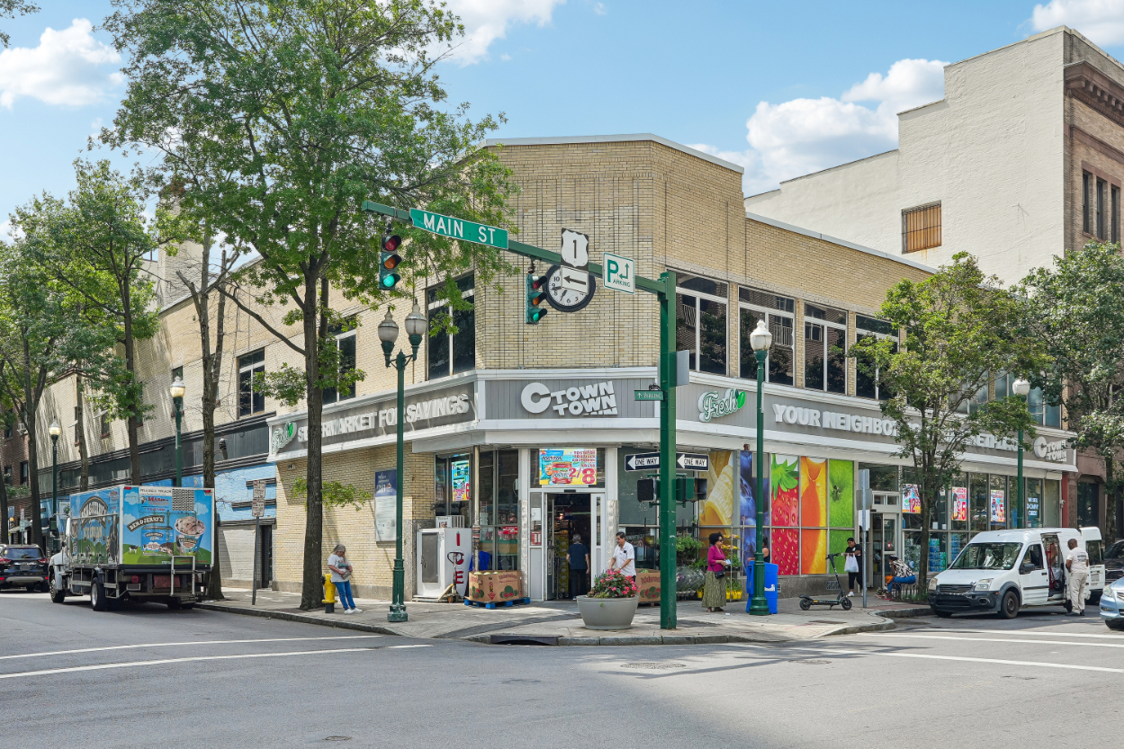 A vibrant corner storefront with a clock and colorful signage.