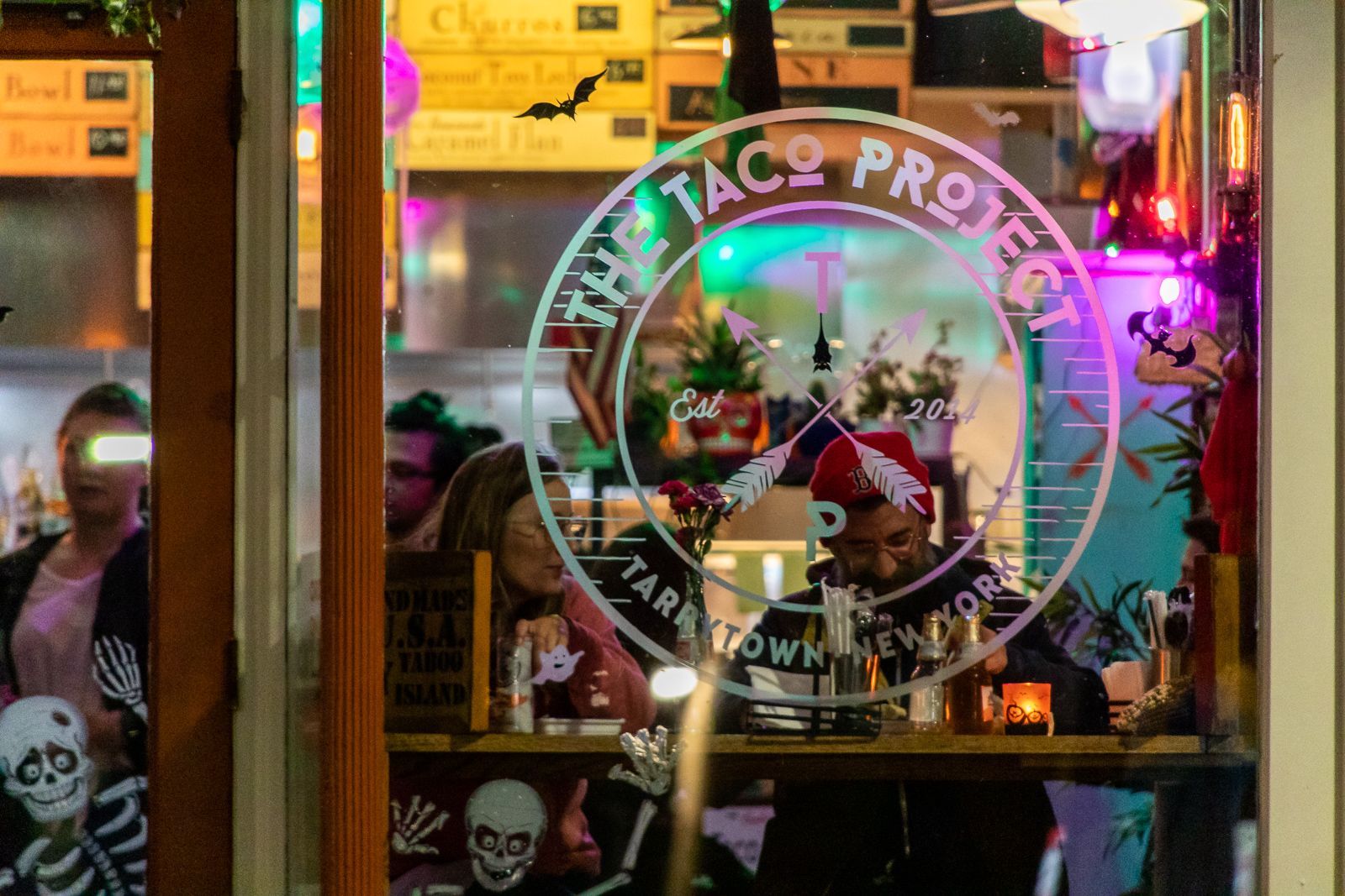Vibrant restaurant window with decorative lights and a logo.