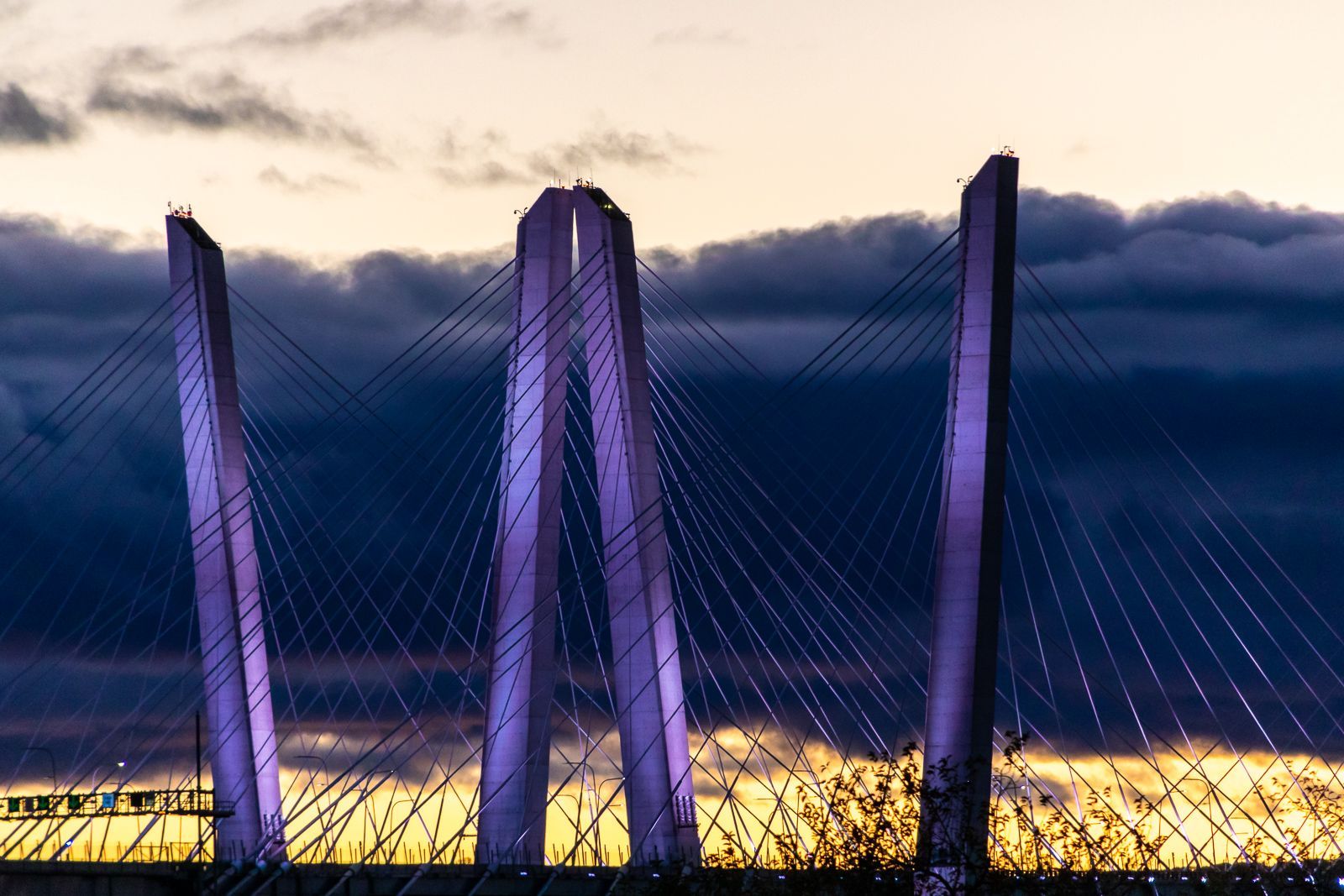 Silhouetted bridge towers against a dramatic sunset sky.