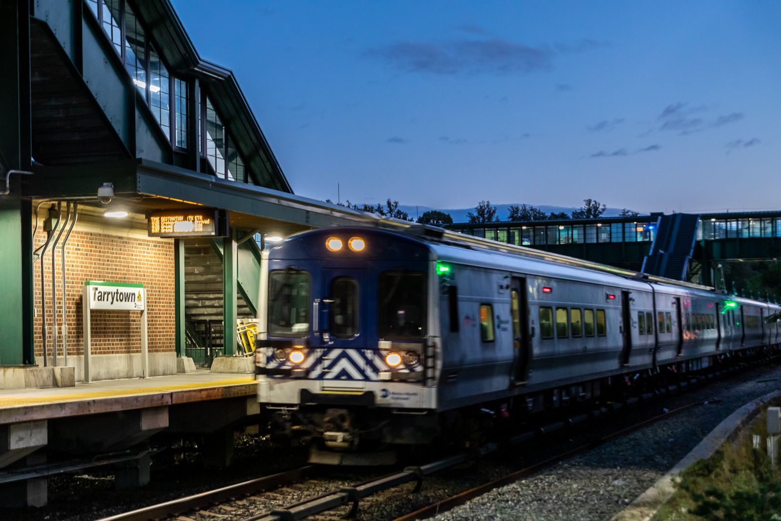 Train arriving at a dimly lit station during twilight.