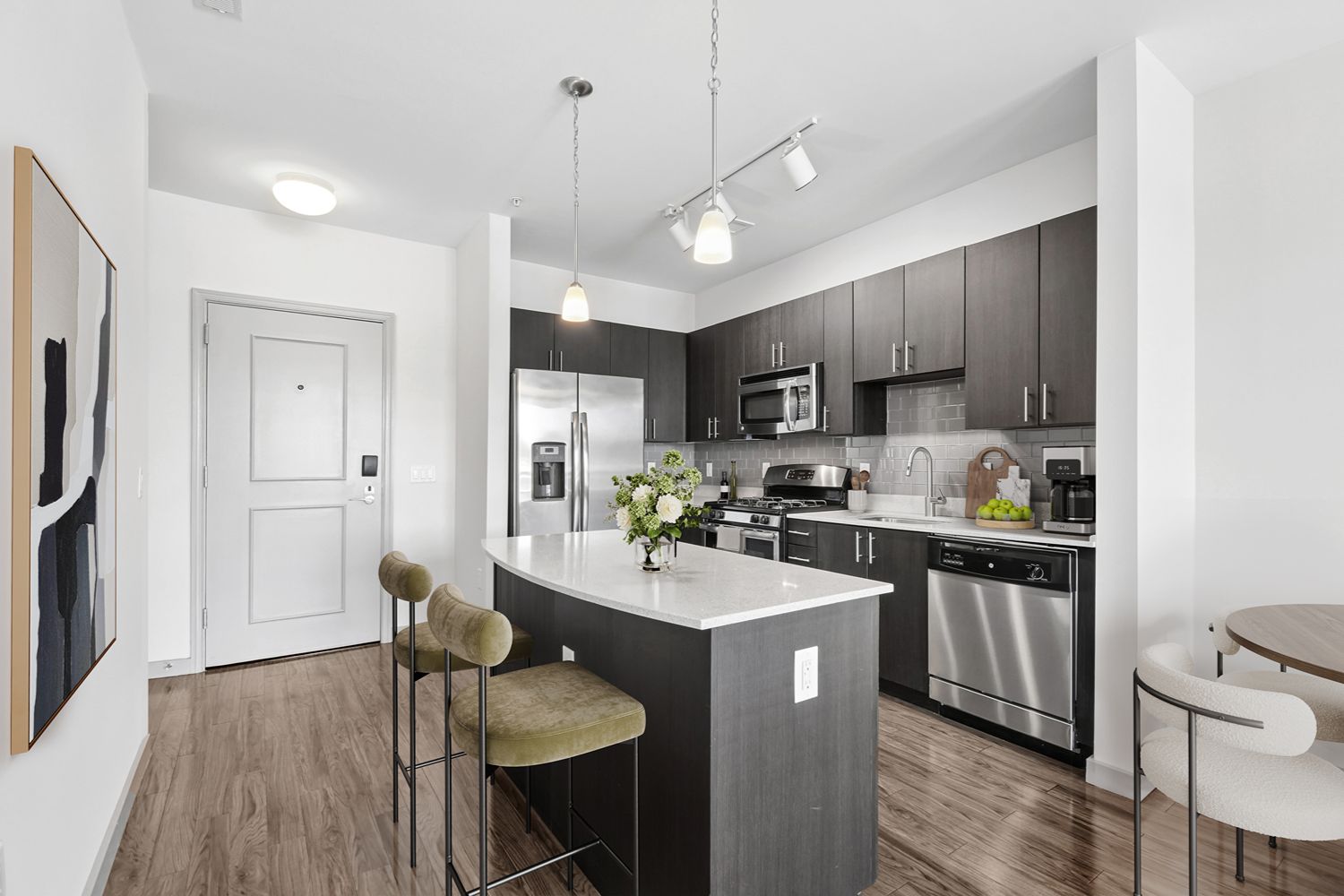Kitchen at 7001 Arlington at Bethesda in Bethesda, MD, featuring quartz countertops, espresso cabinetry, a center island with seating, tile backsplash