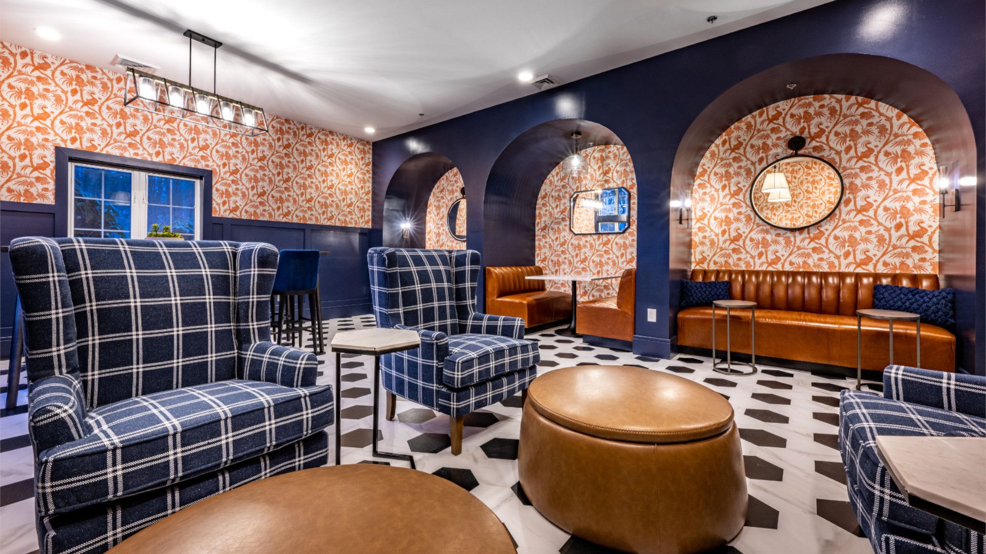 Cozy lounge with patterned chairs, round mirrors, and a decorative wall.
