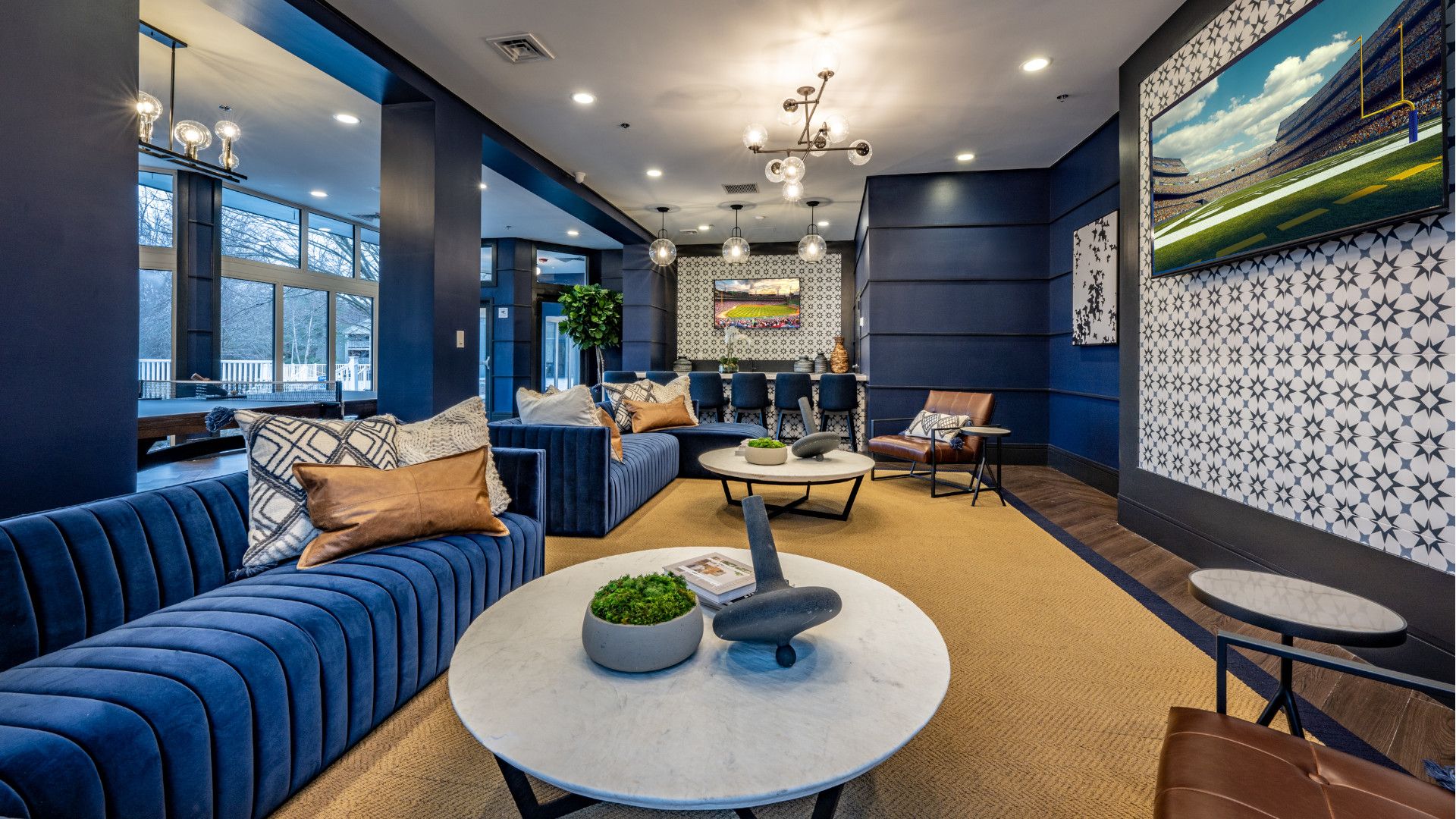 Modern lounge with blue sofas, decorative tables, and stylish decor.