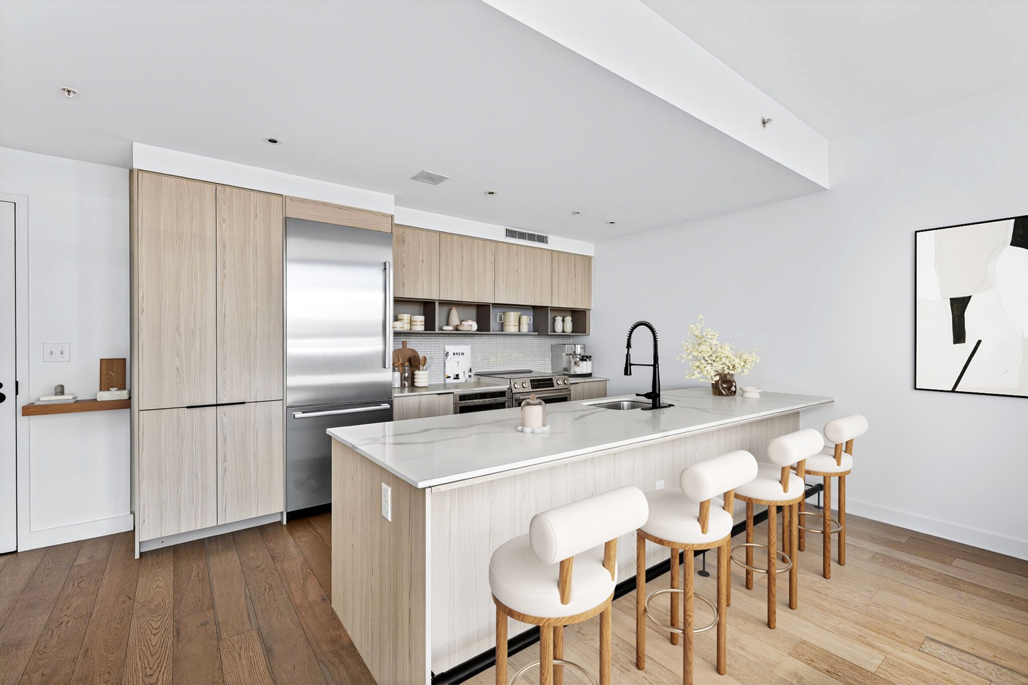 Kitchen with tan cabinetry and barstools