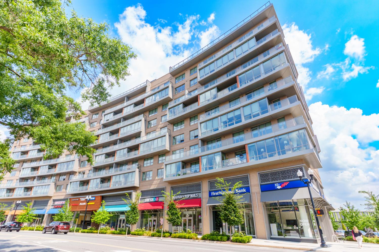 Modern building with shops and bright blue sky.