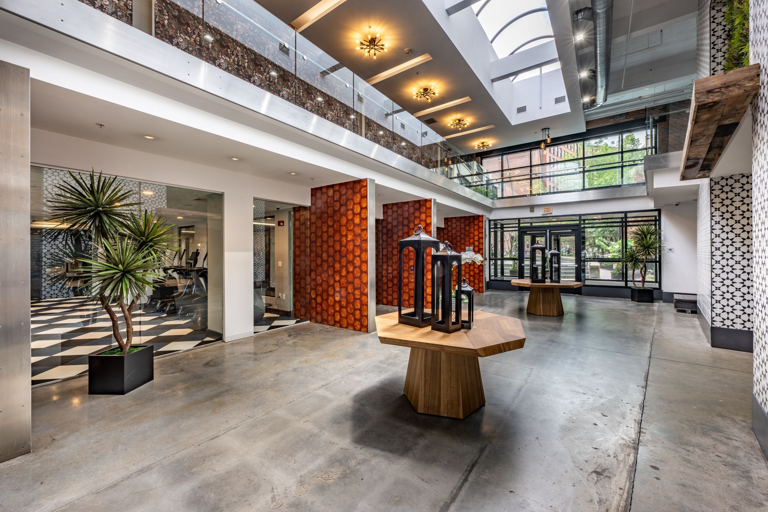 Modern indoor space with open layout, plants, art displays, and large windows.