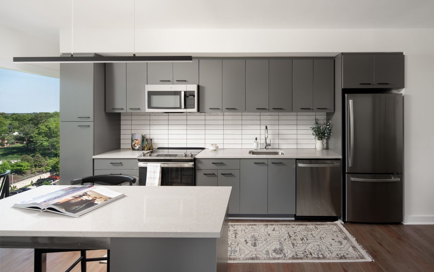 Modern kitchen with gray cabinets, stainless steel appliances, and a minimalist design.
