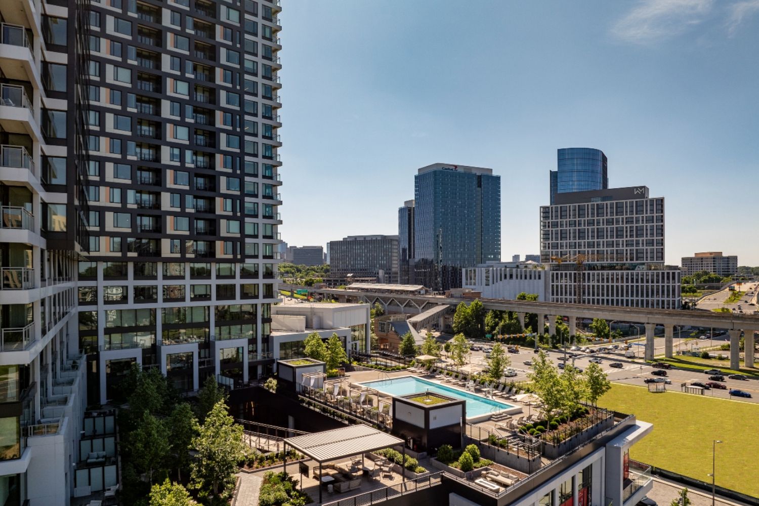 City skyline featuring modern buildings and a rooftop pool area.