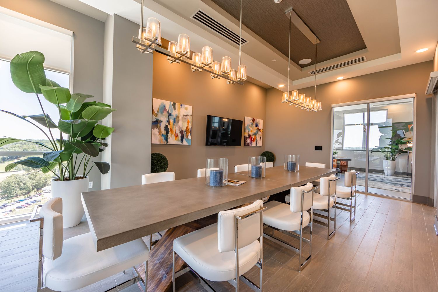 Modern dining area with a long table, stylish chairs, and large windows.