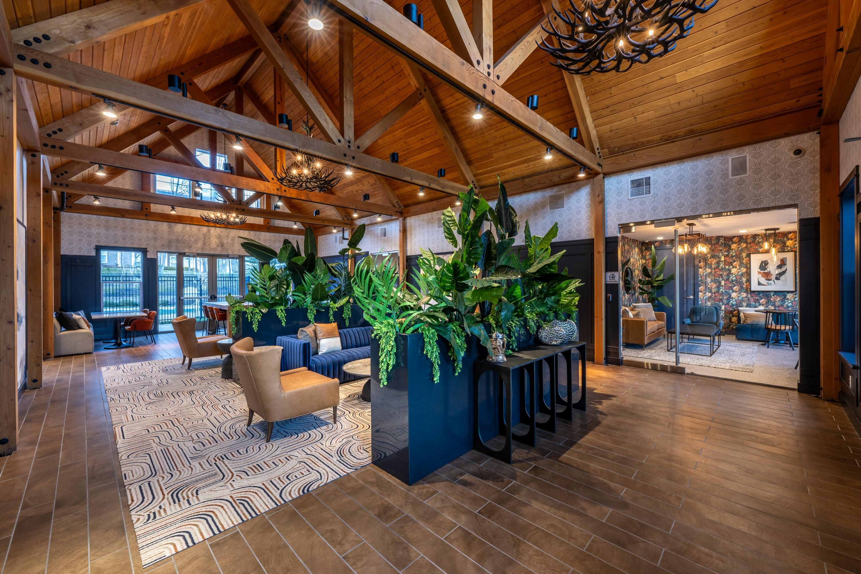 Stylish lobby with wood beams, plants, and seating areas.