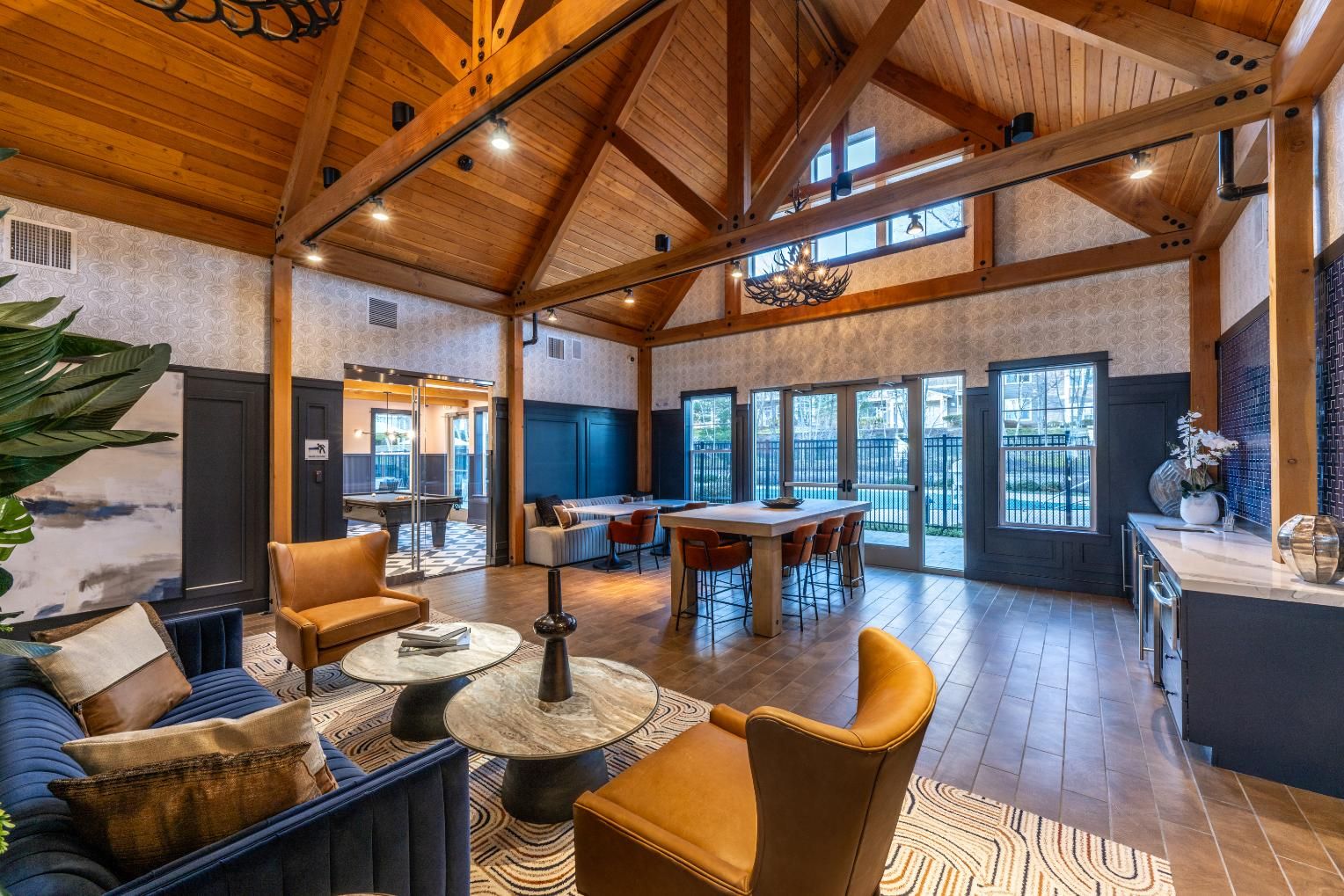 Spacious, modern living area with wooden beams, cozy seating, and large windows.