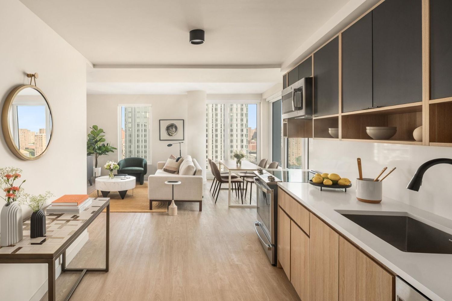 Modern open kitchen and living area with large windows and contemporary furnishings.