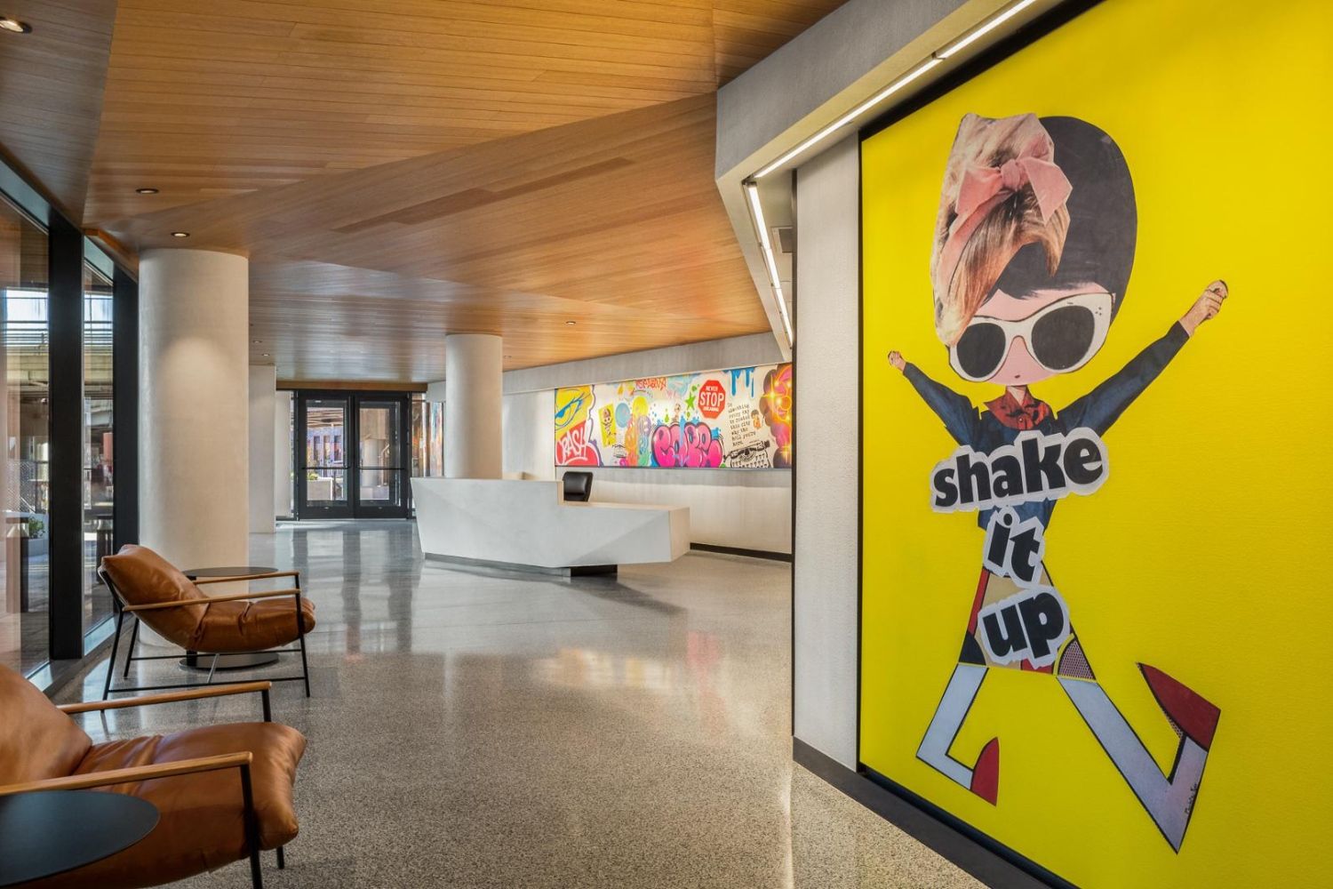 Modern lobby with bright artwork and a playful graphic design on a wall.