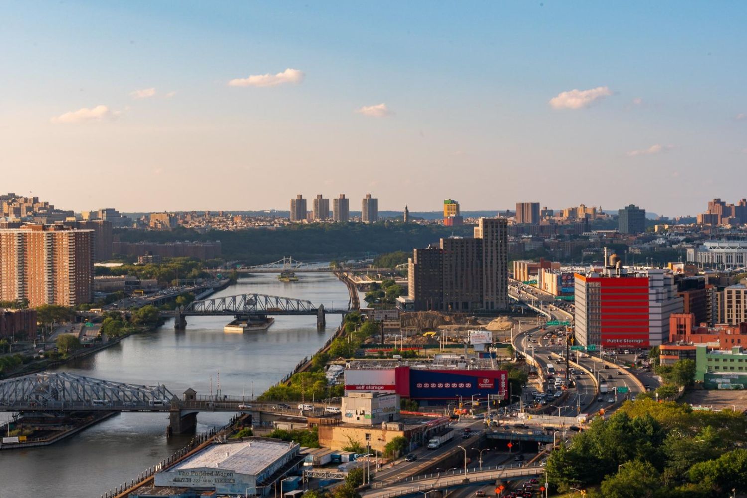 City skyline with buildings and a river under a clear blue sky.