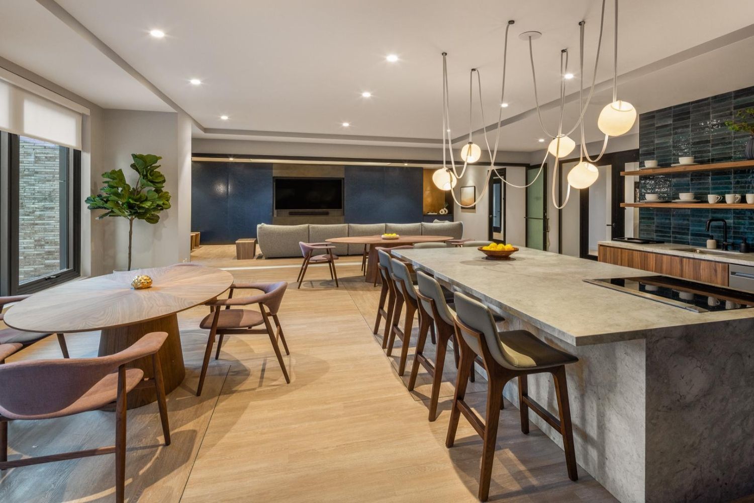 Modern open-plan kitchen and dining area with sleek furnishings and pendant lighting.