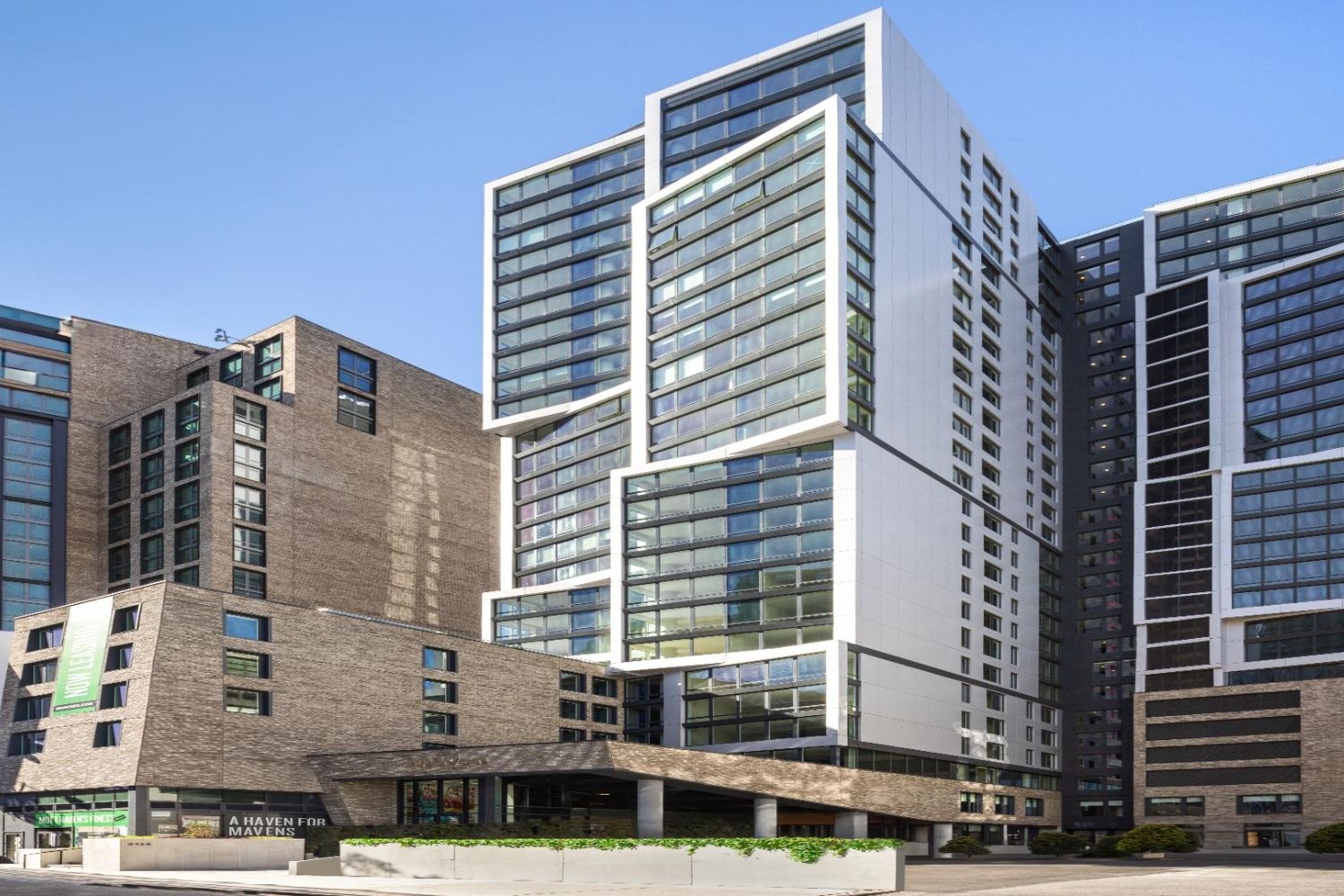 Modern buildings with a mix of glass and concrete façades against a clear blue sky.