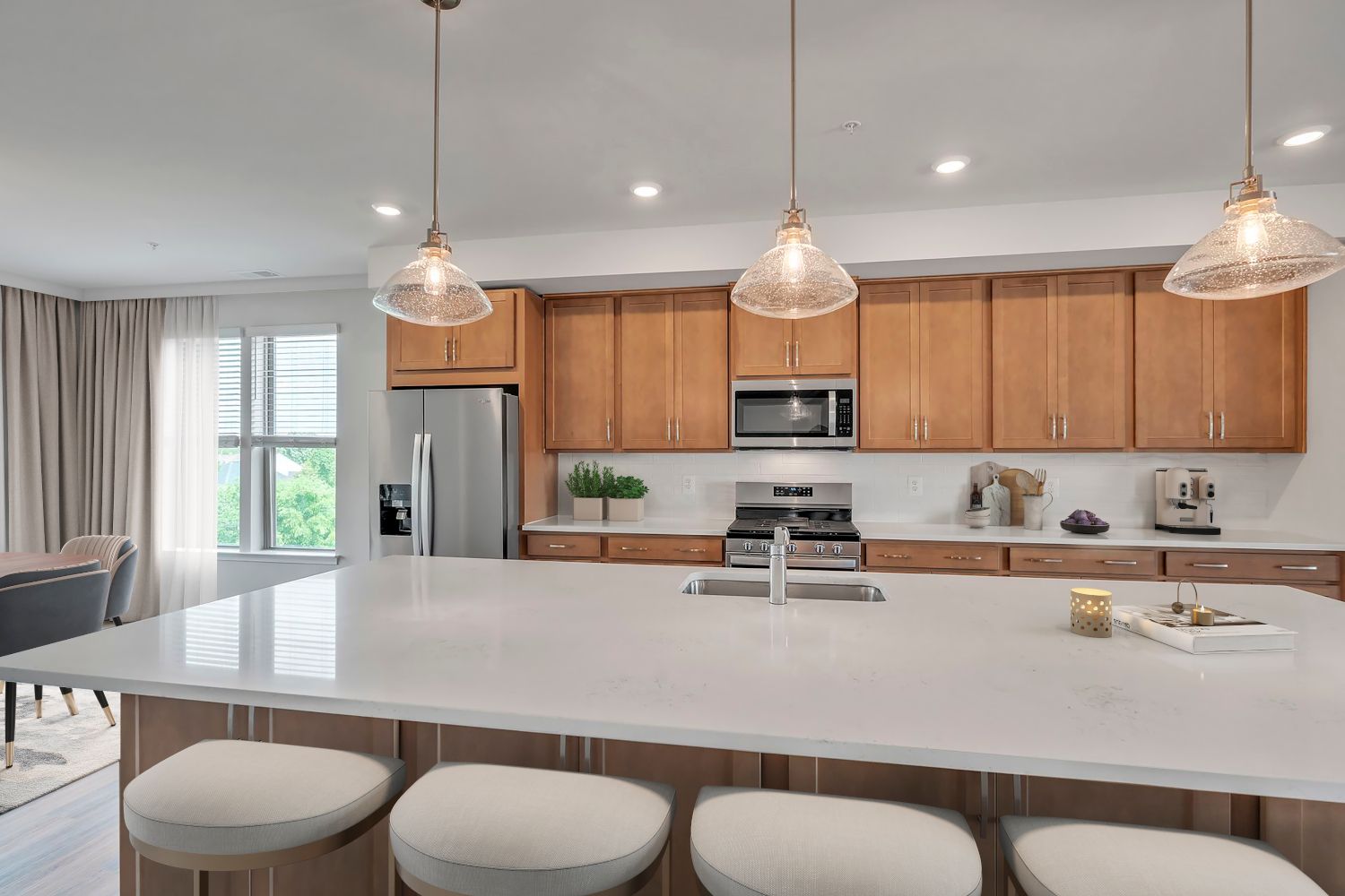 Modern kitchen with wooden cabinets, a large island, and pendant lighting.