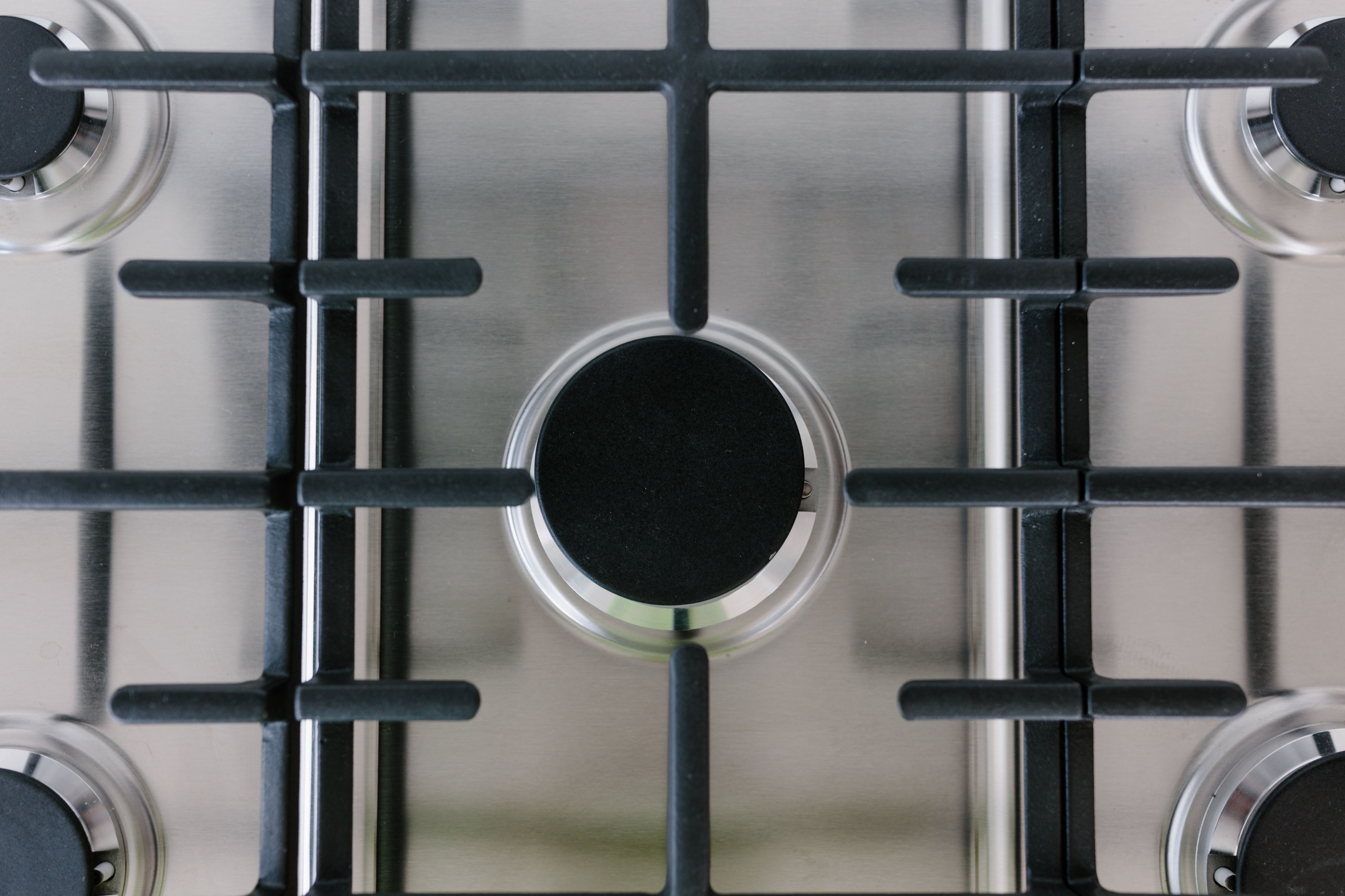 Close-up of a gas stove top with black grates and a central burner.